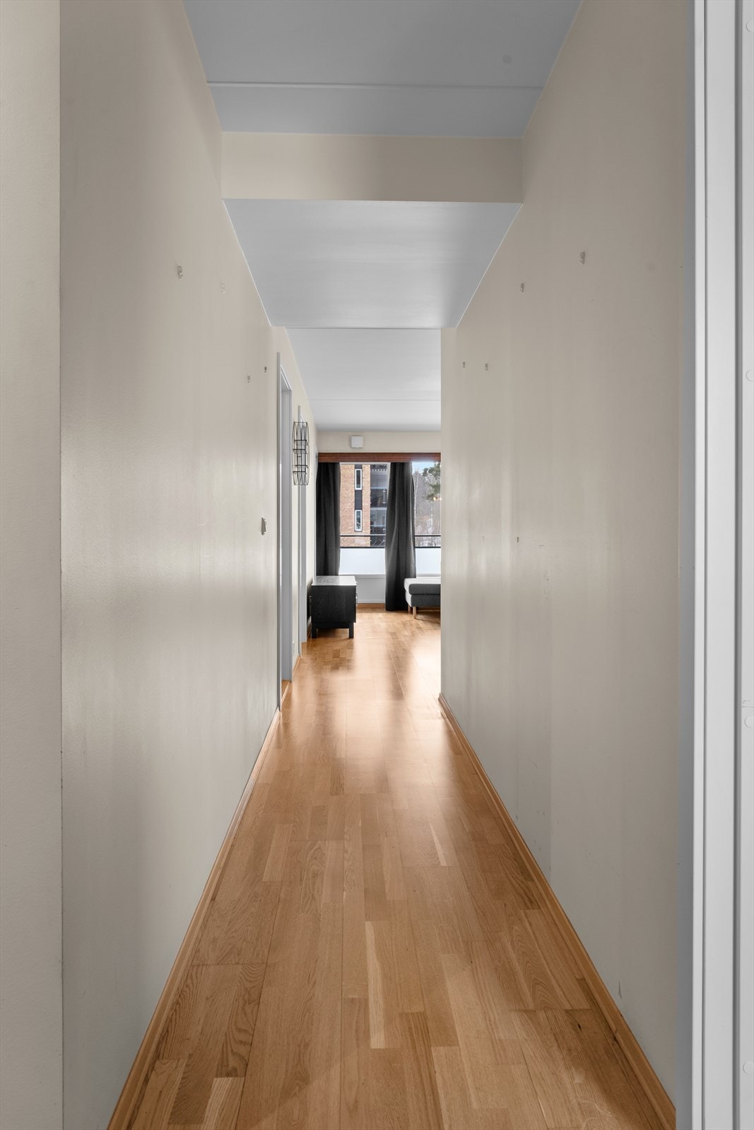 Lang korridor med parkettgulv gir enkel tilgang til de ulike rommene. Galleribilde