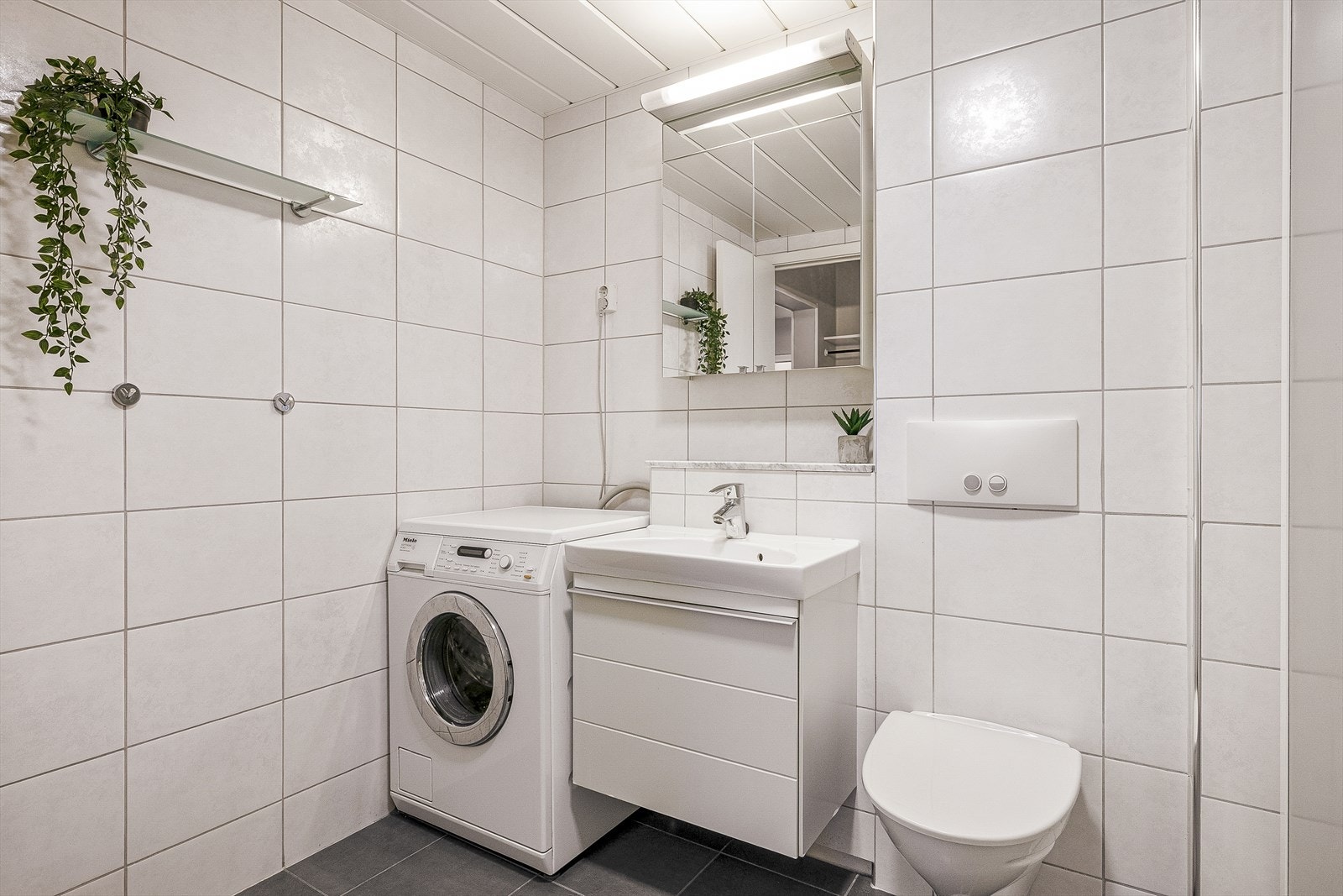 Badet er utstyrt med med hvit baderoms innredning og opplegg for vaskemaskin. Galleribilde