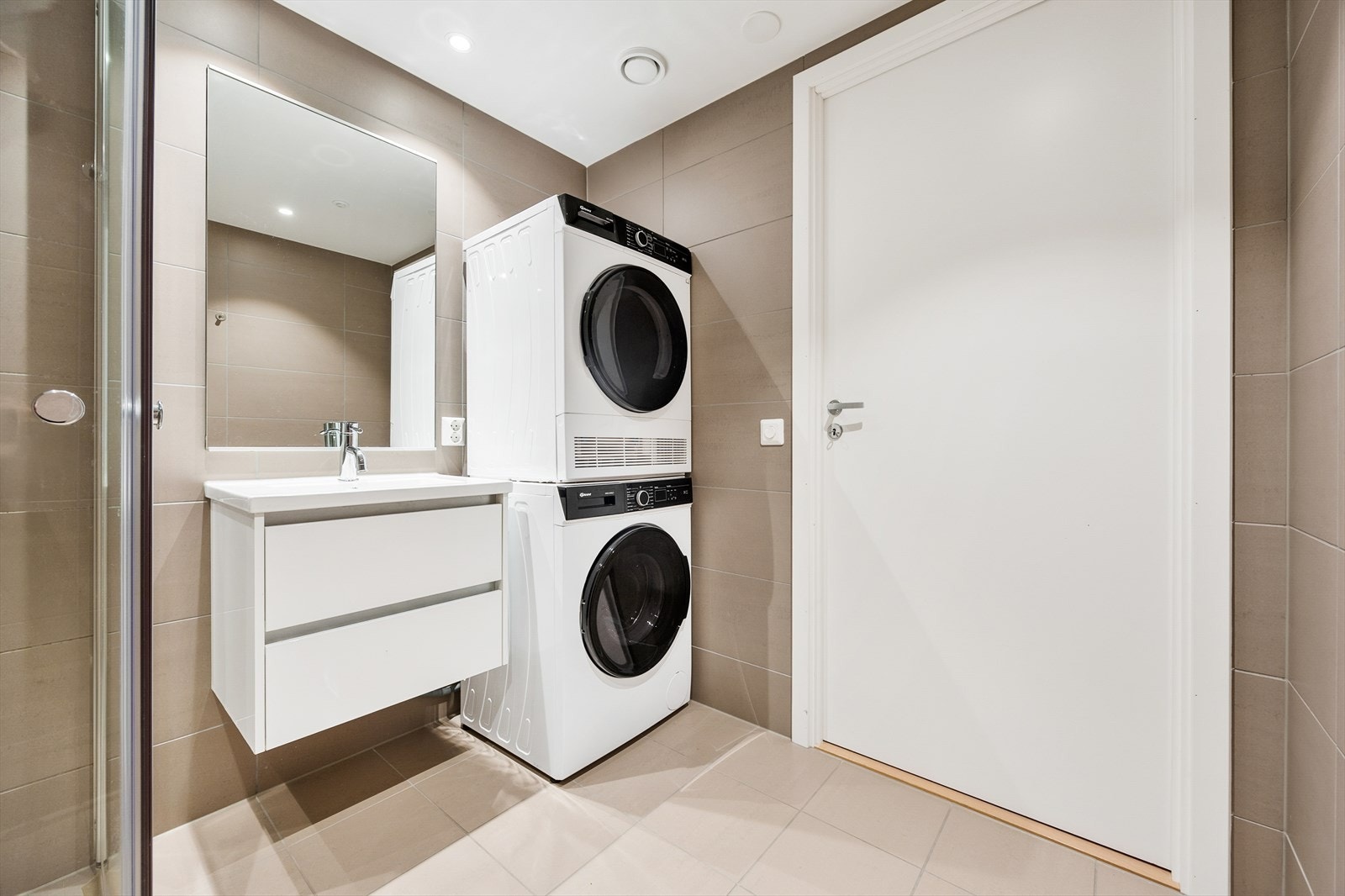 Her er det servantseksjon med skuffer, speil med integrert lys og opplegg for vaskemaskin. Galleribilde