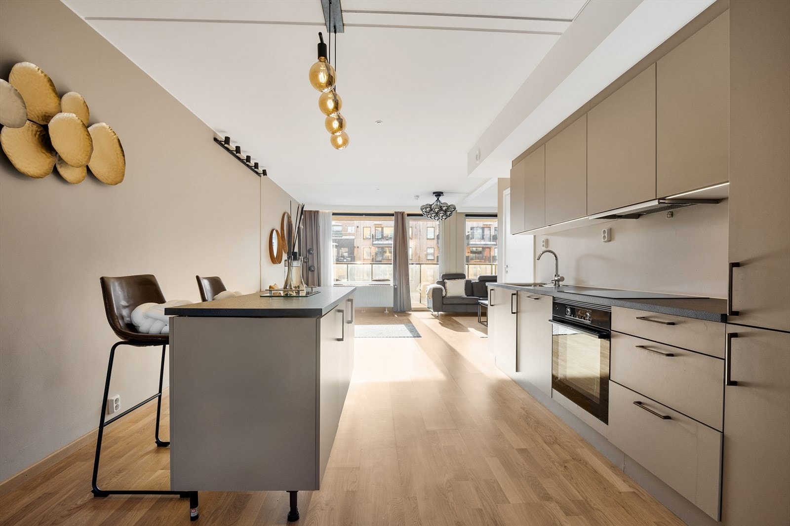 Kjøkkenet har en praktisk kjøkkenøy med laminat benkeplate, integrert oppbevaring og sitteplasser. Galleribilde