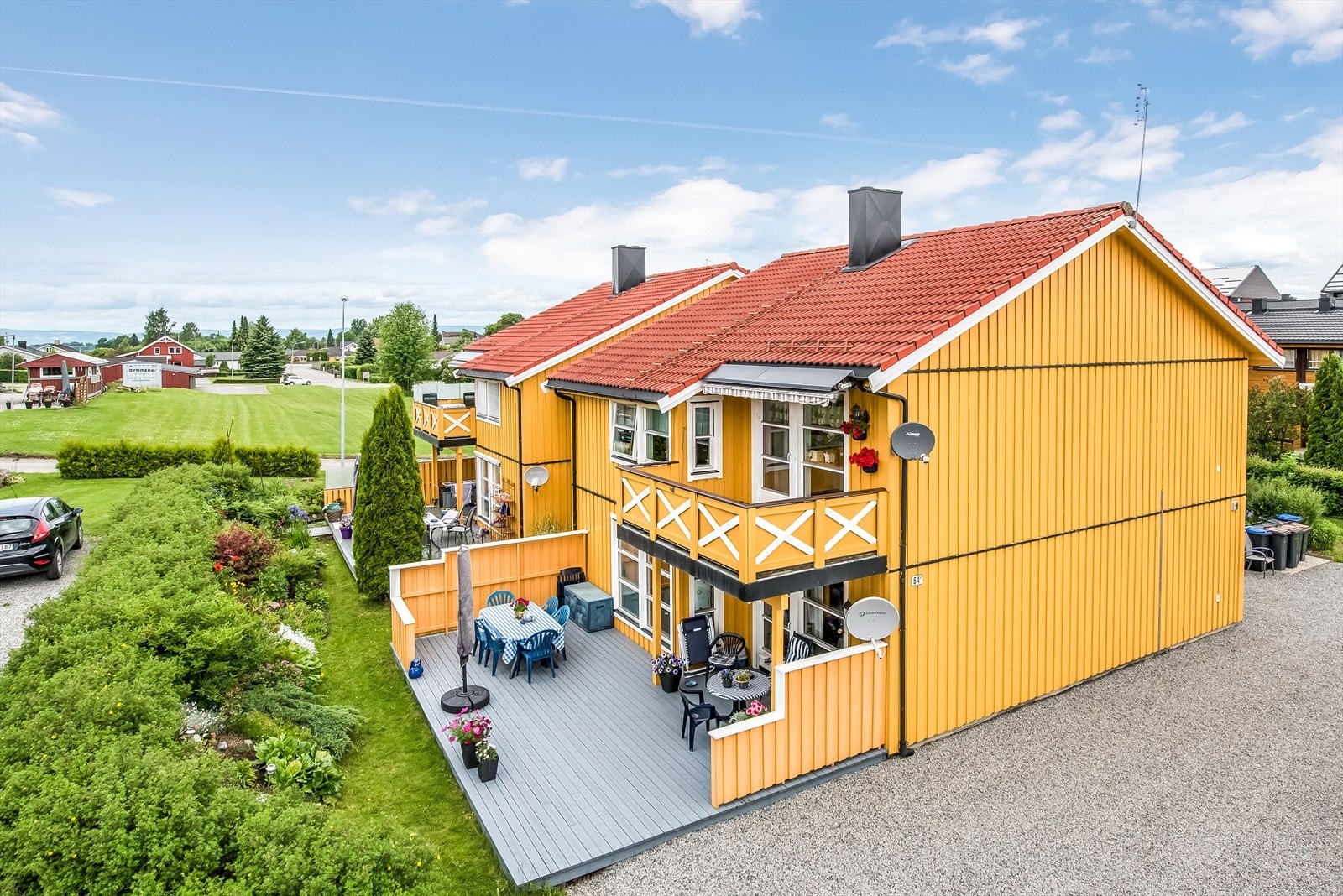 Sommerbilde av bebyggelsen sett fra hage/uteområde. Bildet er eldre og mindre endringer kan ha skjedd. Galleribilde