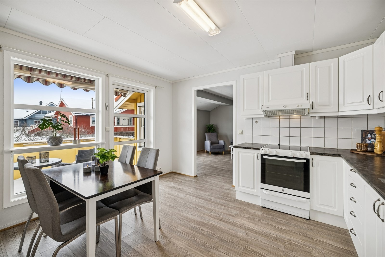 Kjøkken med spiseplass ved vindu og utgang til terrasse. Galleribilde