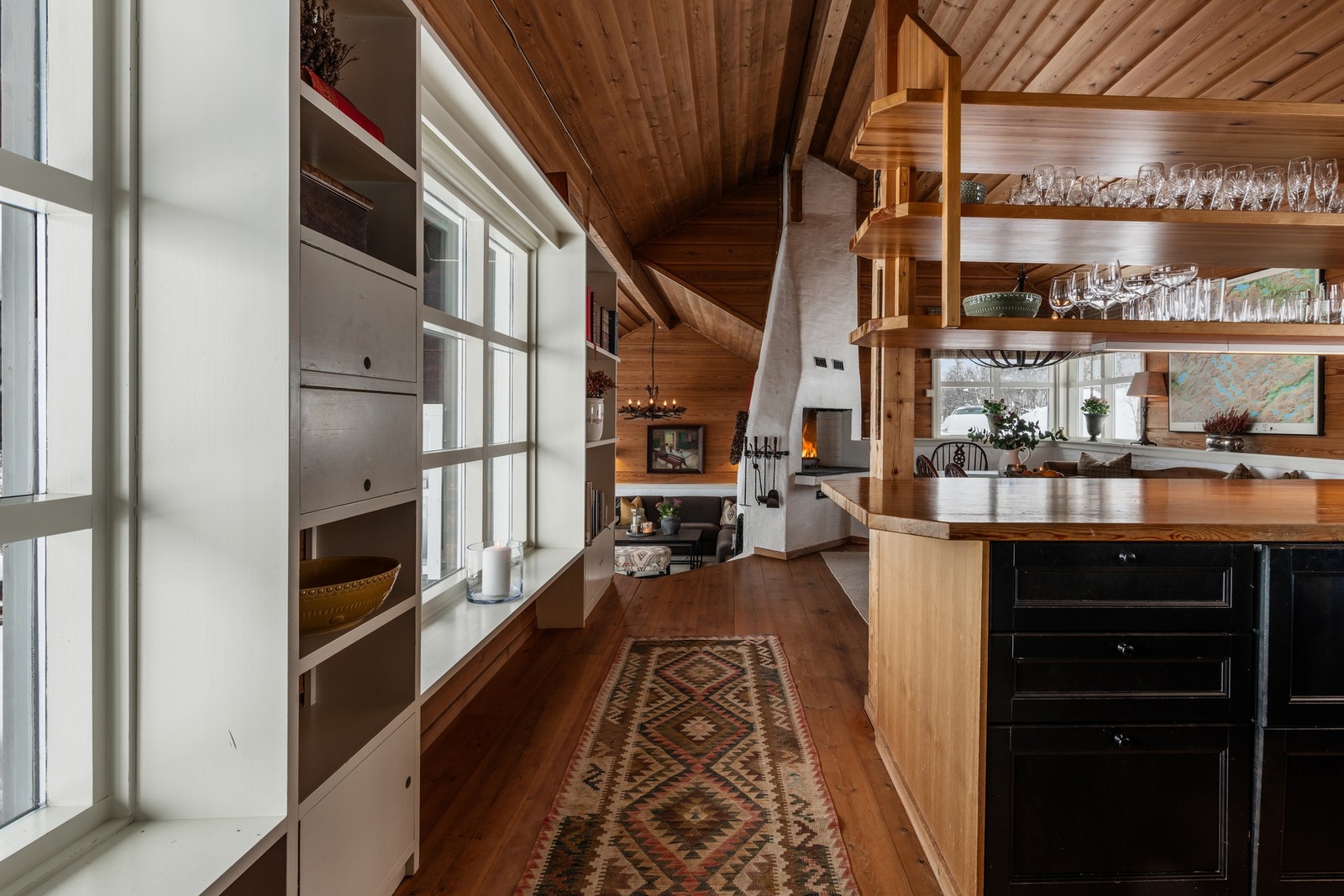 Den åpne stue, spisestue- og kjøkkendelen har en særegen arkitektur med god takhøyde og mye naturlig lys fra store vindusflater Galleribilde