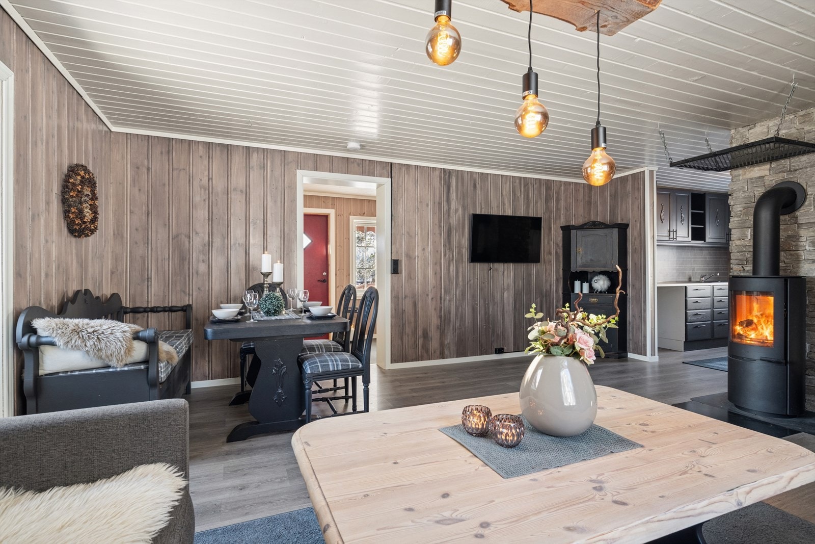 Midtpunktet i stuen er vedovn, som skaper god varme og en lun hytteatmosfære på kjølige dager. Galleribilde