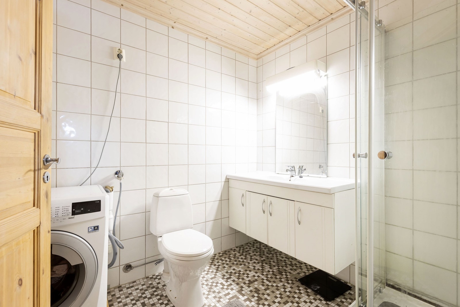 Flislagt bad med varmekabler. Dusjkabinett, servantinnredning, wc og opplegg til vaskemaskin Galleribilde