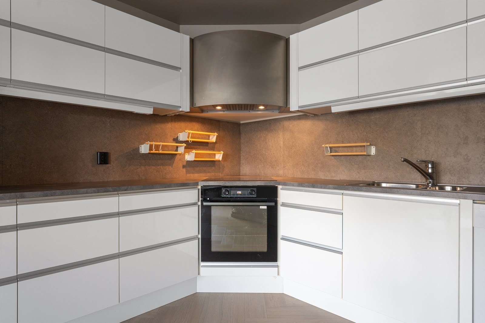 Kjøkkeninnredning med glatte fronter, benkeplate i laminat og nedfelt stålvask med skyllekum, avrenningsbrett og ett-greps blandebatteri Galleribilde