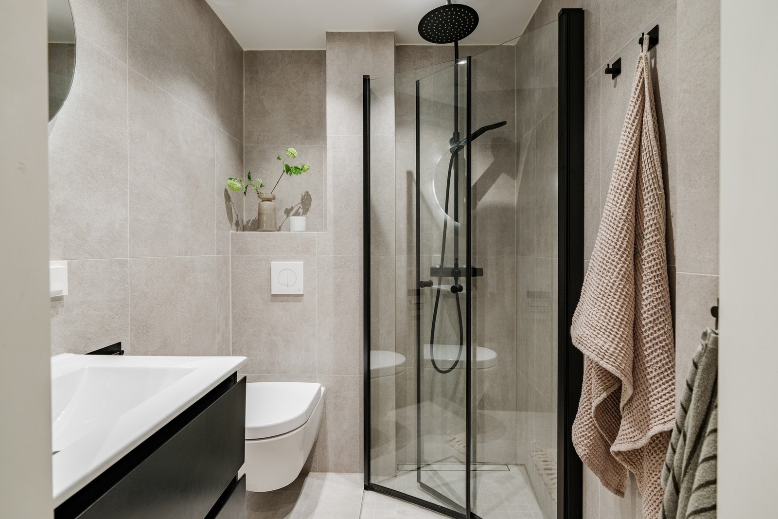 Svært stilrent bad med store fliser på vegger og gulv. Det er varmekabler i gulv. Malt himling med downlights. Galleribilde