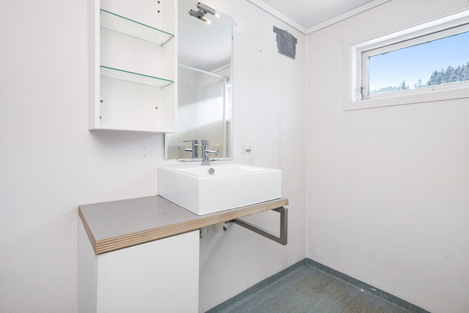 Badet inneholder toalett, helstøpt servant, og dusjkabinett. Galleribilde