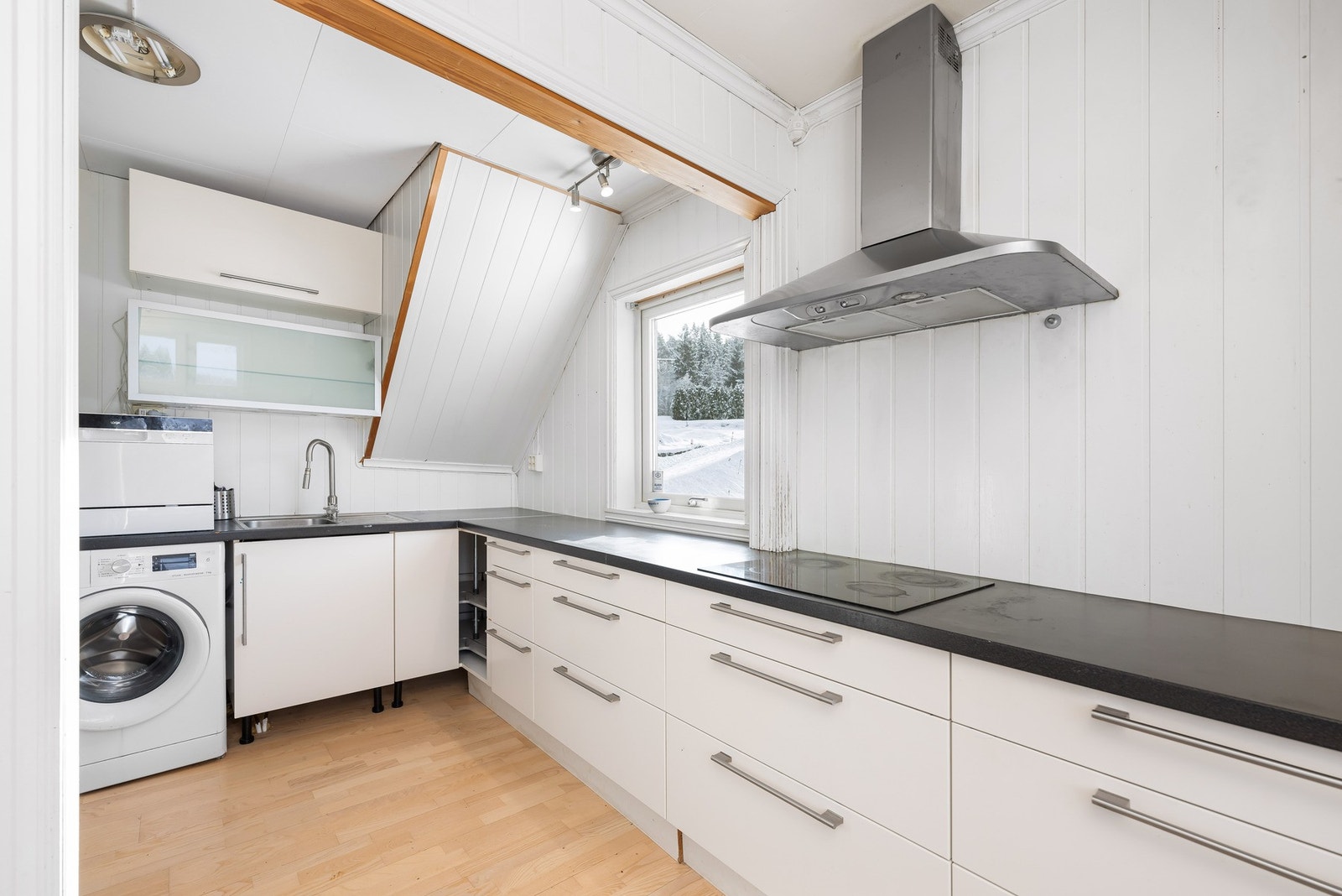 Kjøkkenet har slette fronter og laminat benkeplate med stål oppvaskkum. Galleribilde