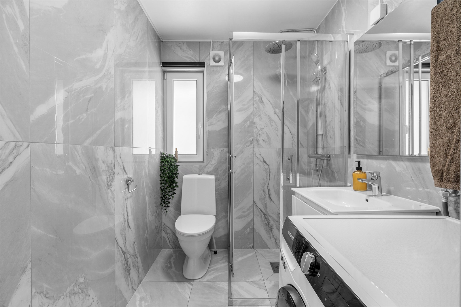 Rommet er innredet med toalett, dusjhjørne med skyvedører i glass og vegghengt servantskap med skuffer og ovenpåliggende servant med ettgreps armatur. Galleribilde