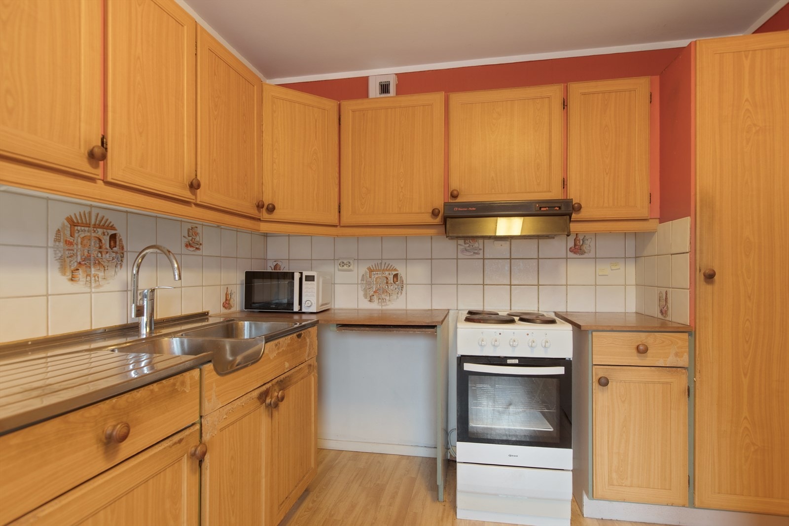 Innredning med profilerte fronter, laminat benkeplate og fliser over. Dobbel stålbenkebeslag. Galleribilde