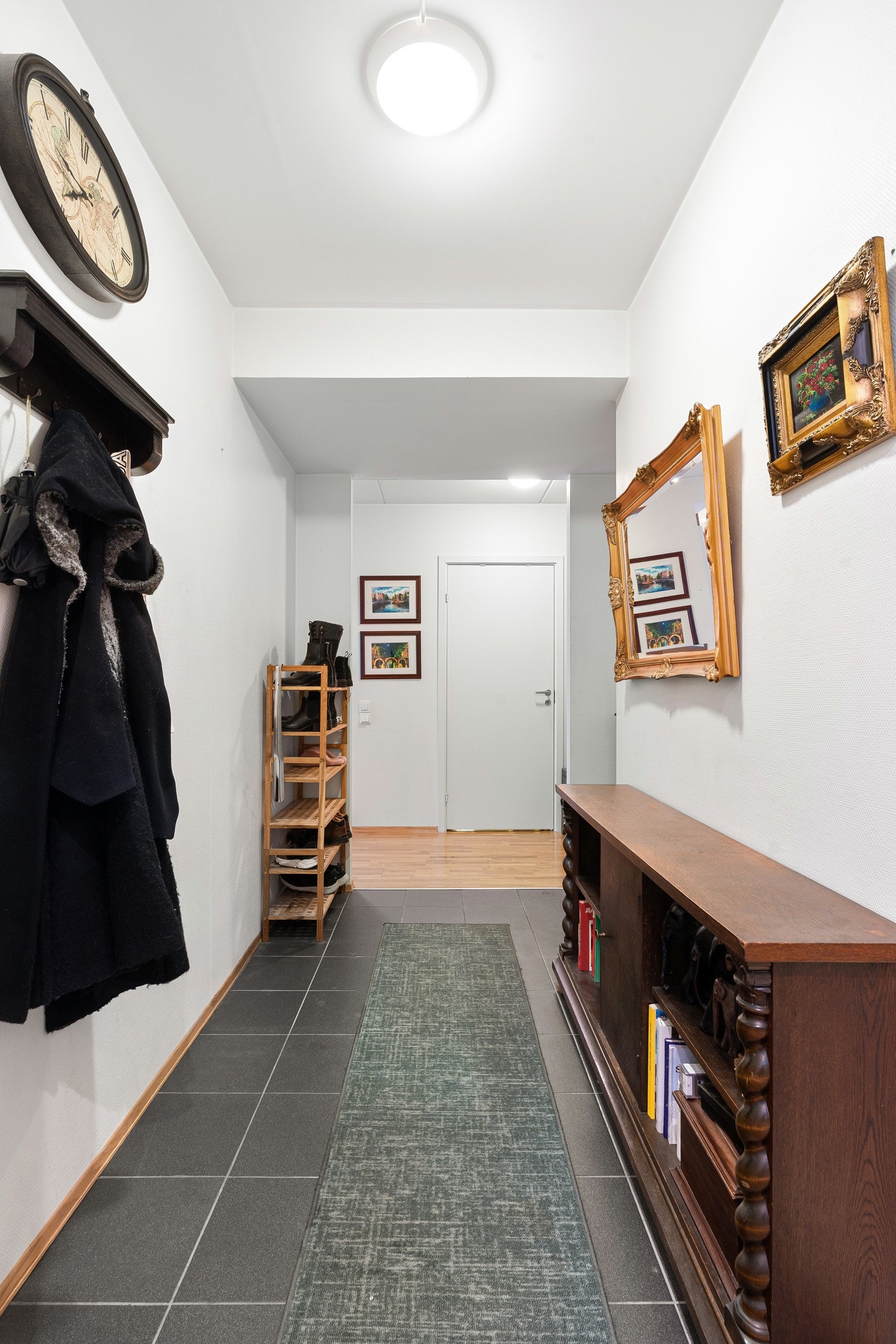 Velkommen inn! Flislagt inngangsparti med plass til å henge av seg yttertøyet.