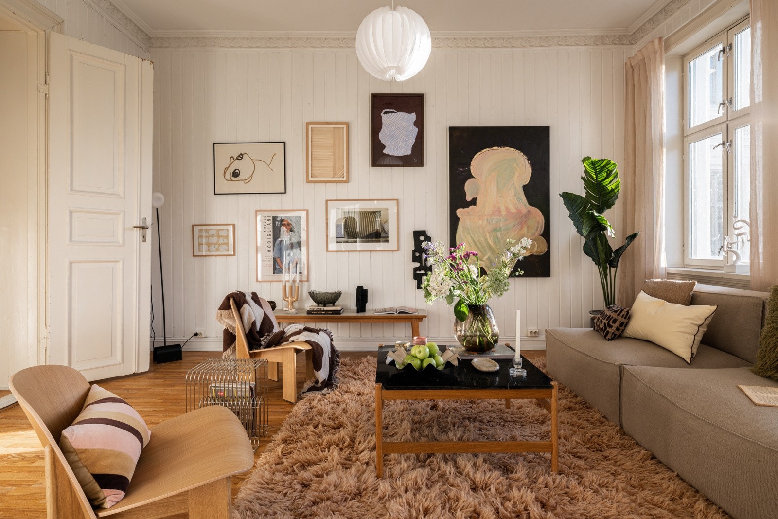 Sjarmerende stue med laminat på gulv, lysmalt trepanel på veggene og klassiske detaljer. Galleribilde