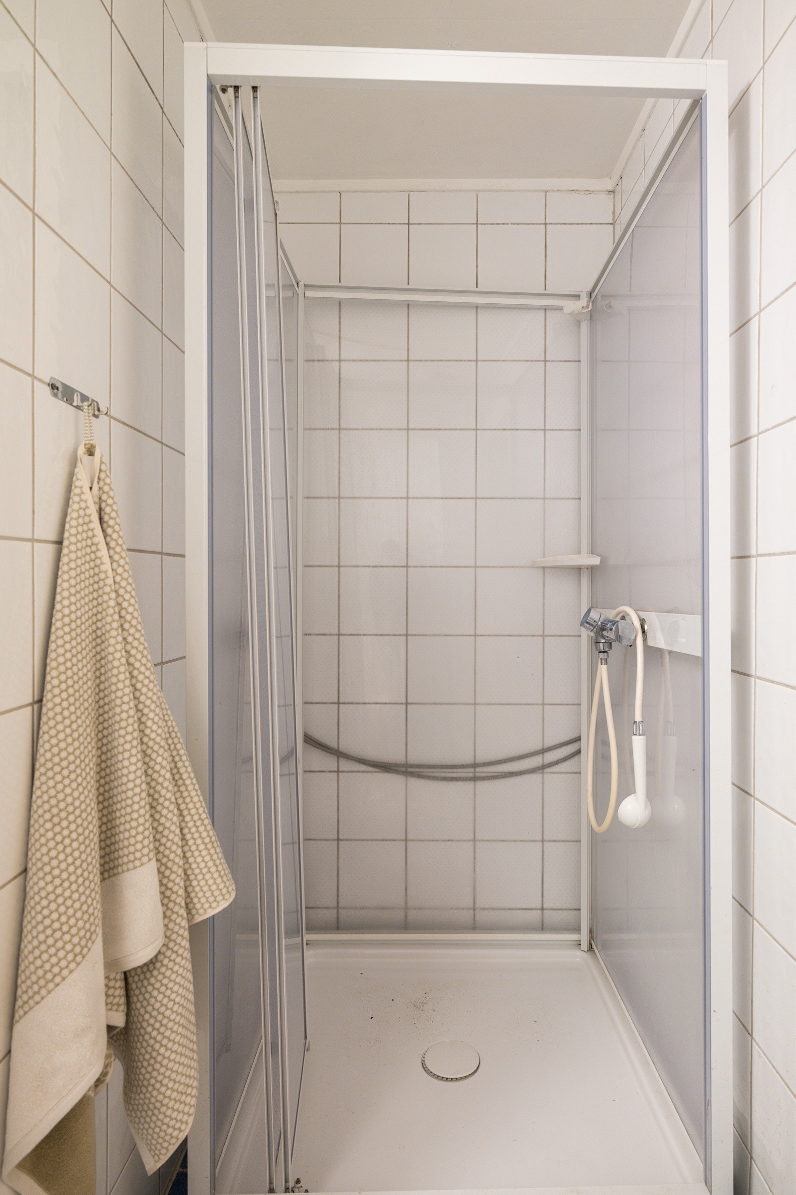 Baderommet har blå fliser på gulv med varmekabler (ukjent tilstand) og hvite fliser på veggene. Galleribilde