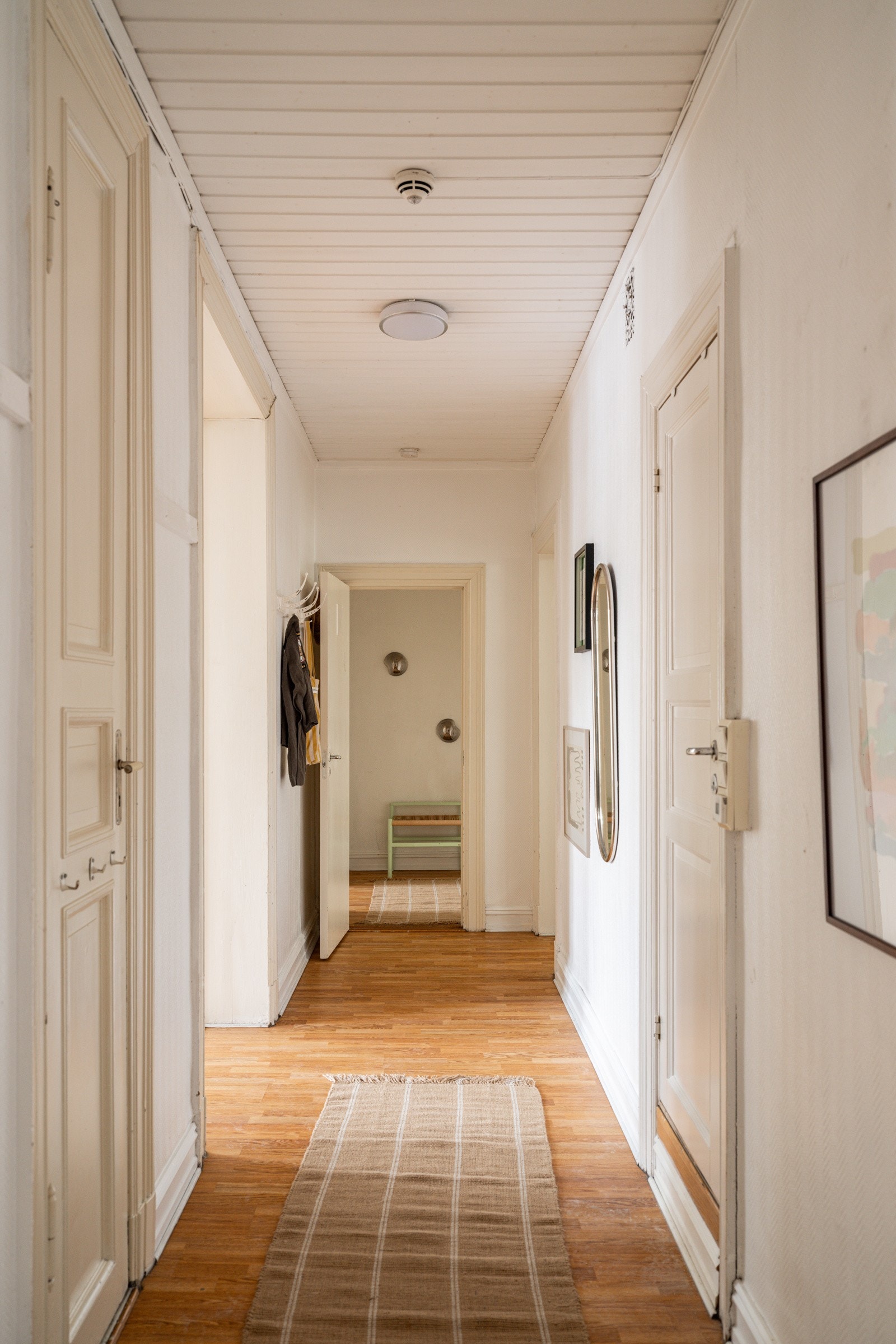 Entréen har laminat på gulv og lysmalte overflater. Galleribilde