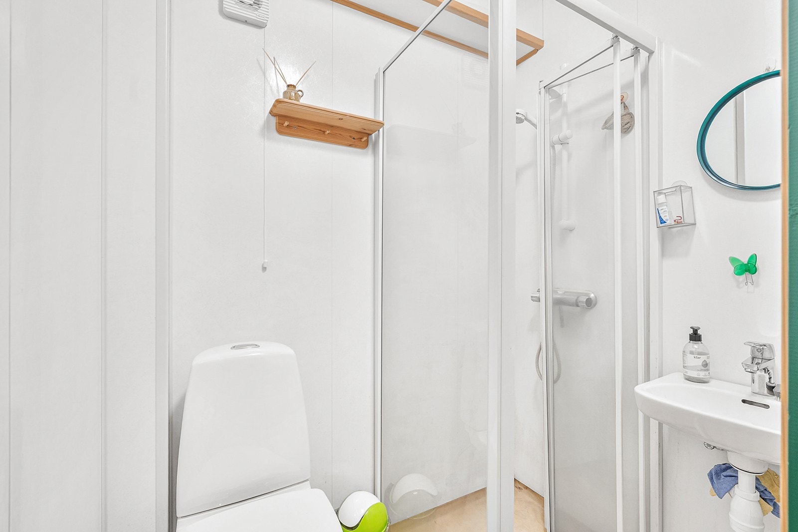Bad i kjeller har våtromsbelegg på gulv, baderomsplater på vegger og trepanel i himling, samt servant, gulvstående toalett og dusj med glassvegger. Galleribilde