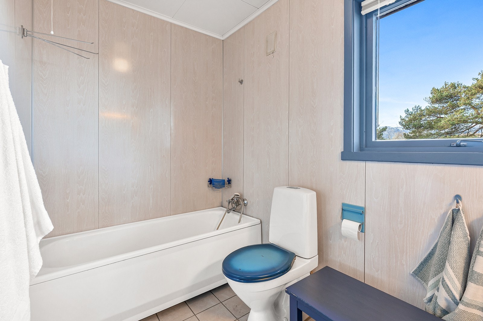 Badet i 1. etasje har flislagt gulv, baderomsplater på vegger og trepanel i himling Galleribilde