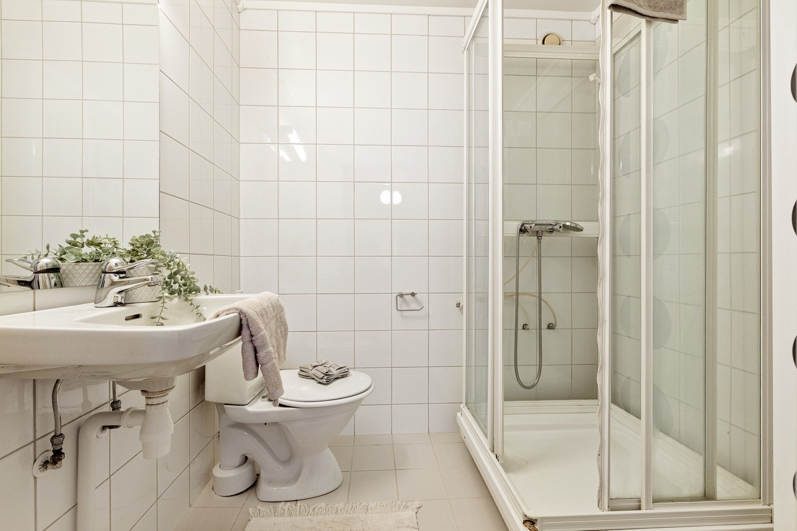 Eldre bad innredet med servant, toalett og dusjkabinett Galleribilde