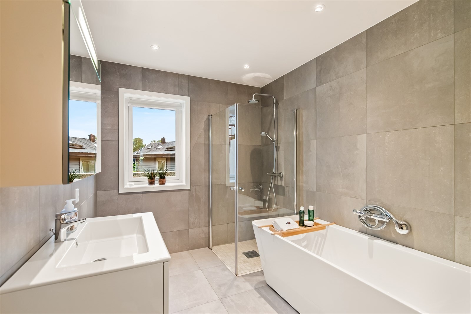 Av innredning er det badekar, dusjhjørne, og vegghengt toalett. Baderomsinnredning av servantbenk nedfelt i innredning med skuffer og overhengt speil. Galleribilde