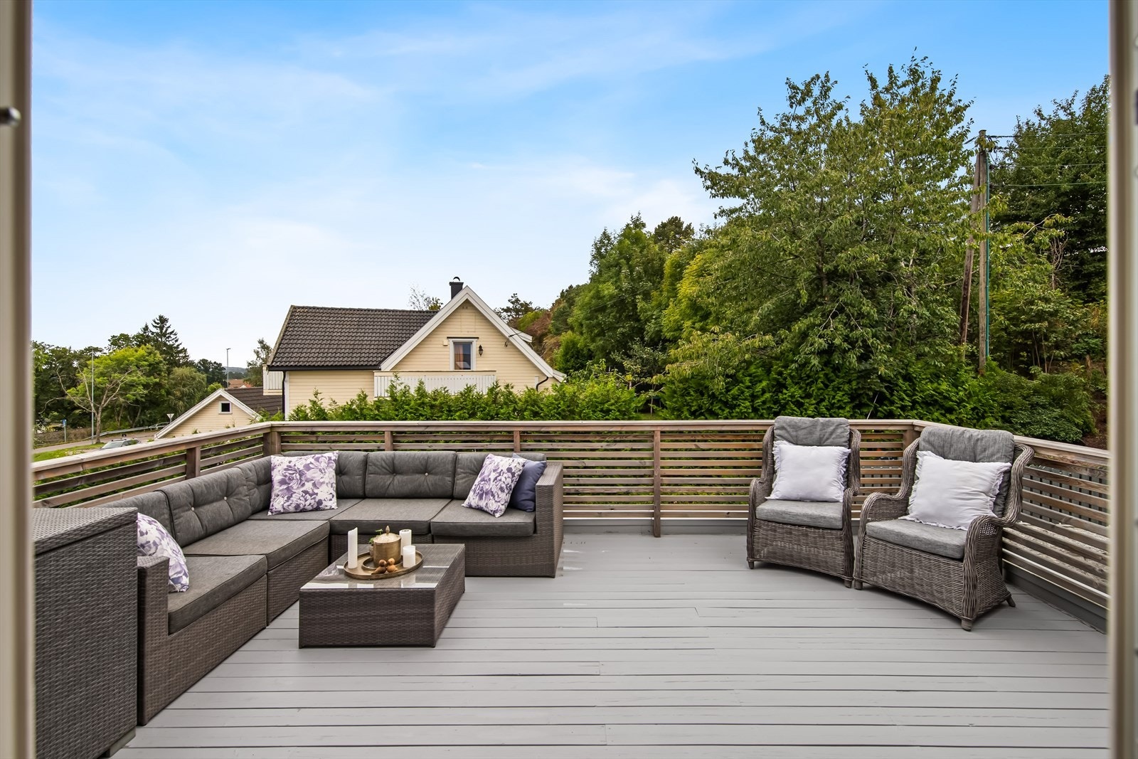 Terrassen er opparbeidet på dekke av tre og pent innrammet med rekkverk av liggende spiler. Galleribilde