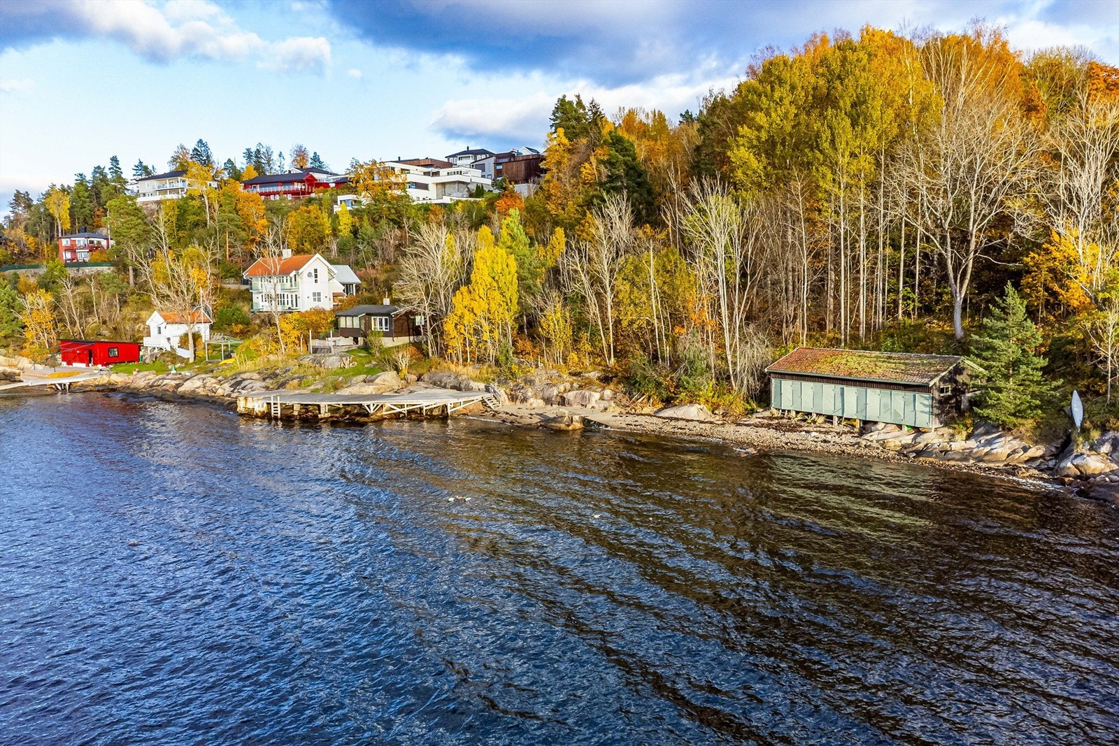 Nær strandkanten står båthus og én av totalt ni hytter på eiendommen. Byggeforbud og restriksjoner gjelder innenfor 100-metersbeltet langs sjøen. Galleribilde