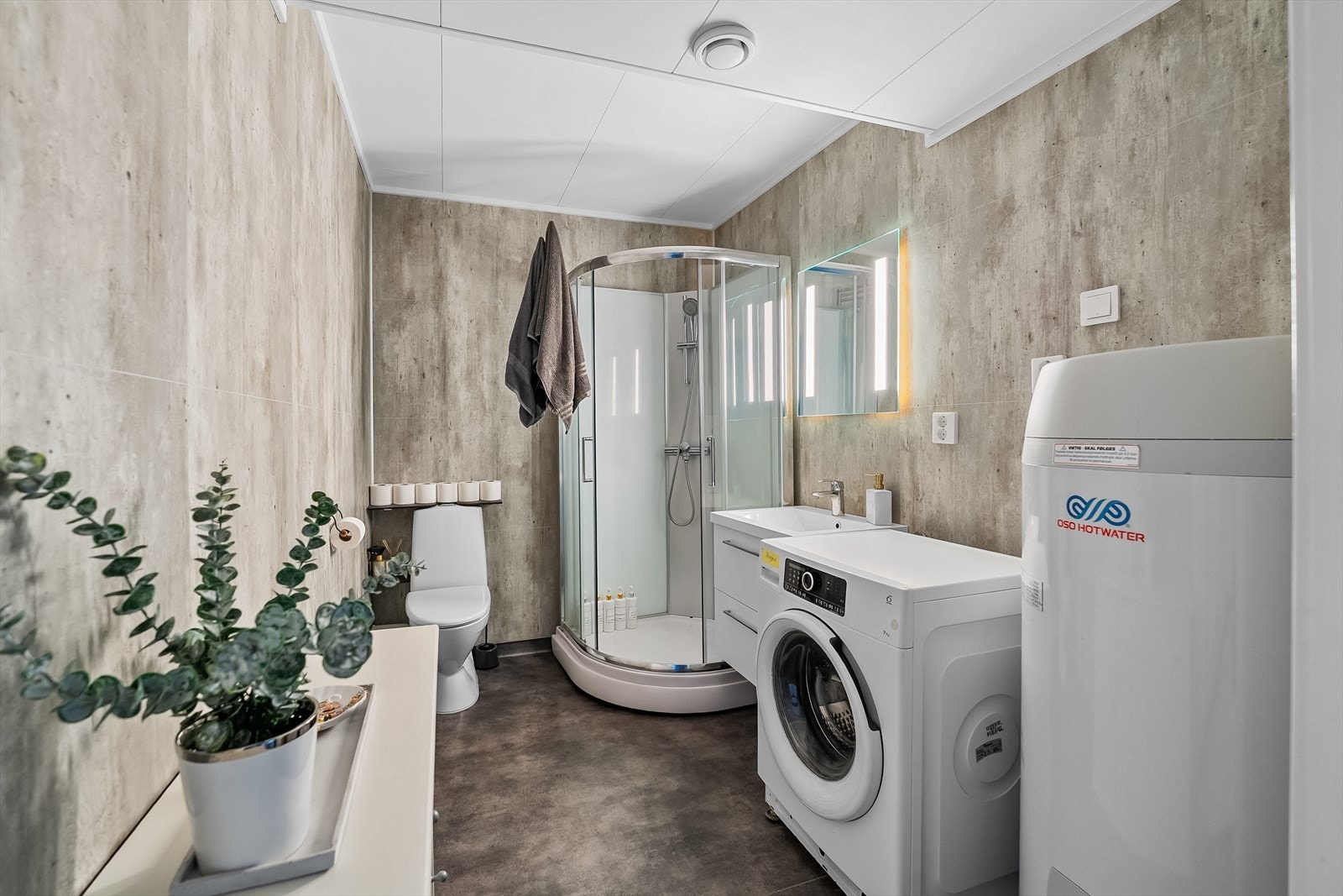 Bad med kabinettdusj, svevende servant med speil med integrert belysning og toalett. Galleribilde