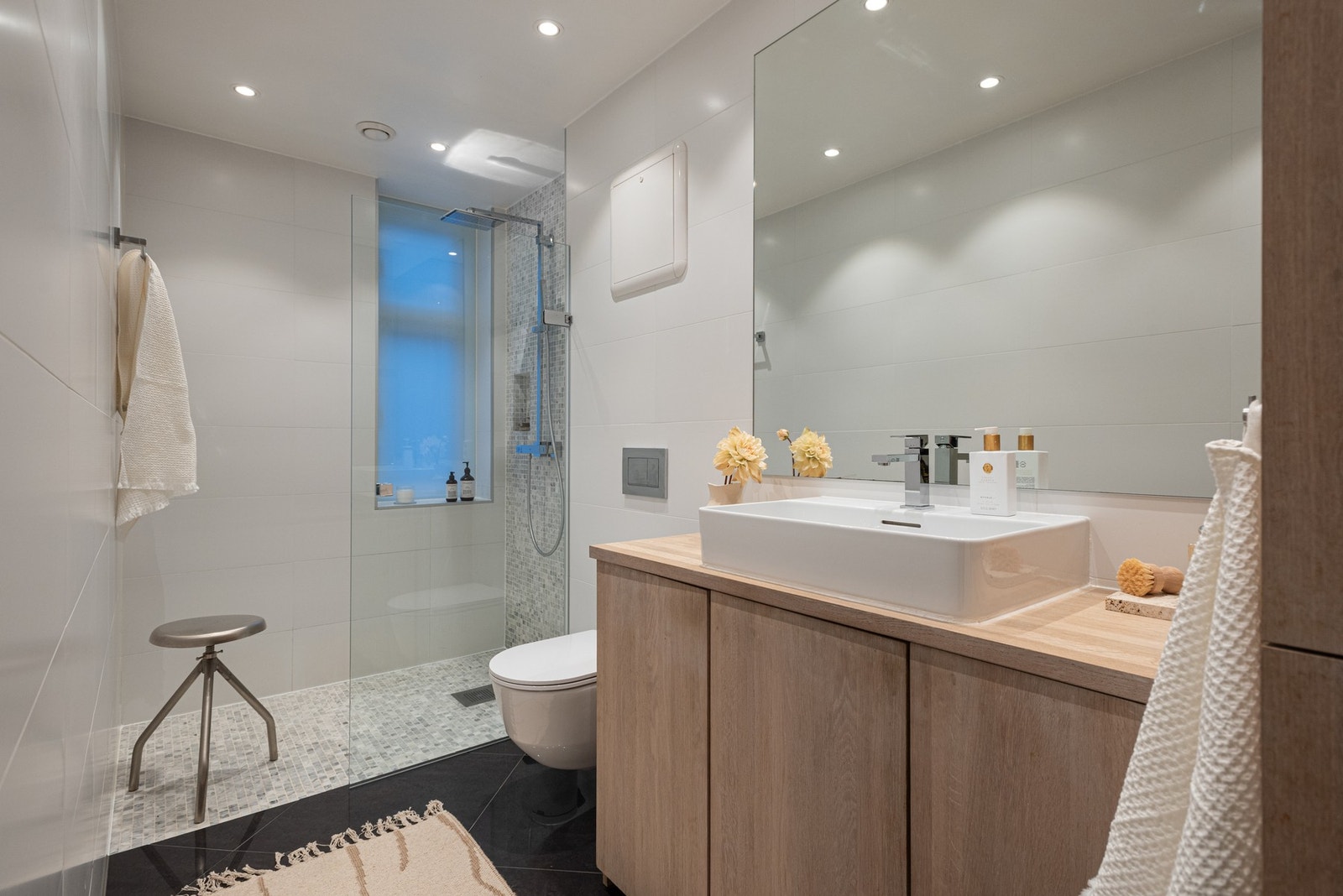 Baderommet har termostatstyrte varmekabler i gulv, downlights i himling, samt opplegg for vaskemaskin og tørketrommel i skapinnredning. Galleribilde