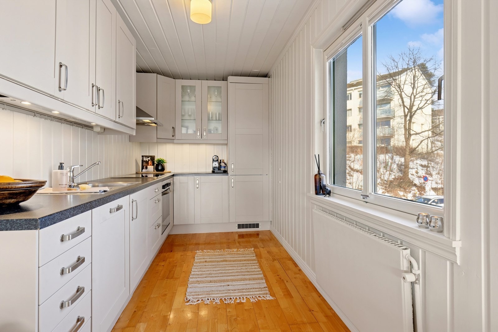 Nymalt kjøkkeninnredningen med profilerte fronter med masse oppbaverings- og benkeplass. Galleribilde