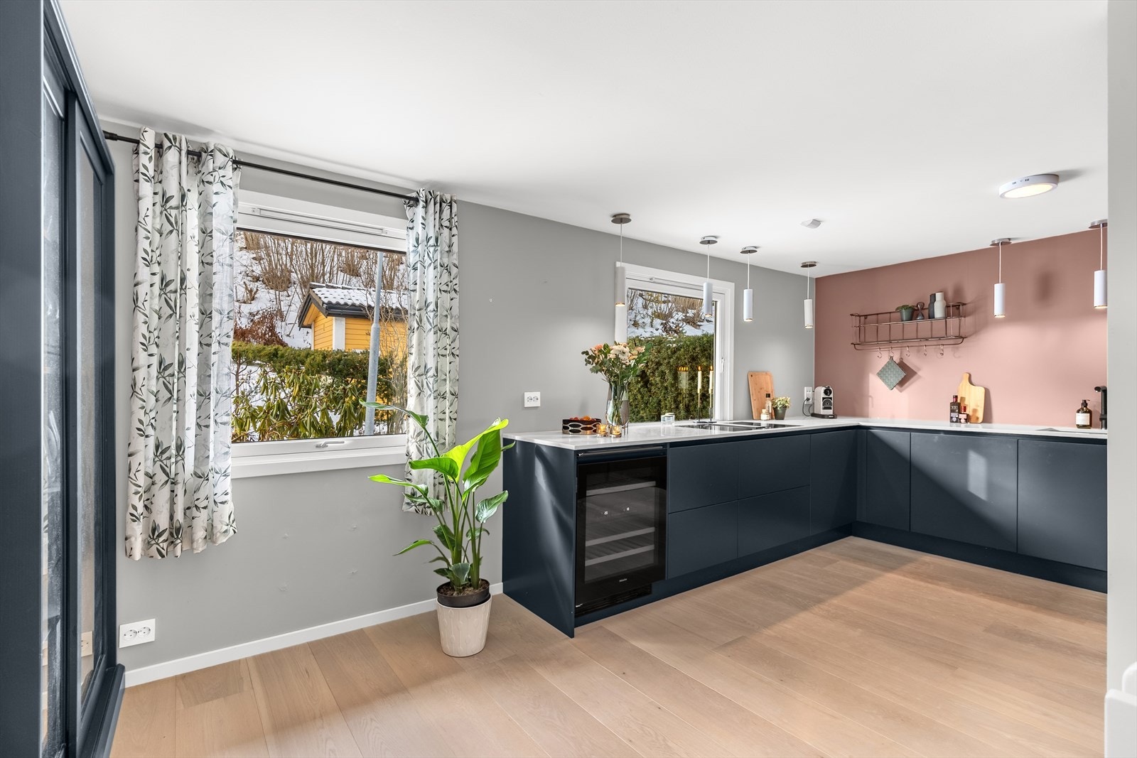 Moderne innredning med glatte fronter. Komposittstein benkeplate med en tykkelse på 20mm. Underlimt oppvaskkum med ettgreps armatur fra Blanco. Nedfelt avtrekk i platetopp. Det er integrert stekeovn, platetopp, oppvaskmaskin, vinskap og kjøl/fryseskap. Galleribilde