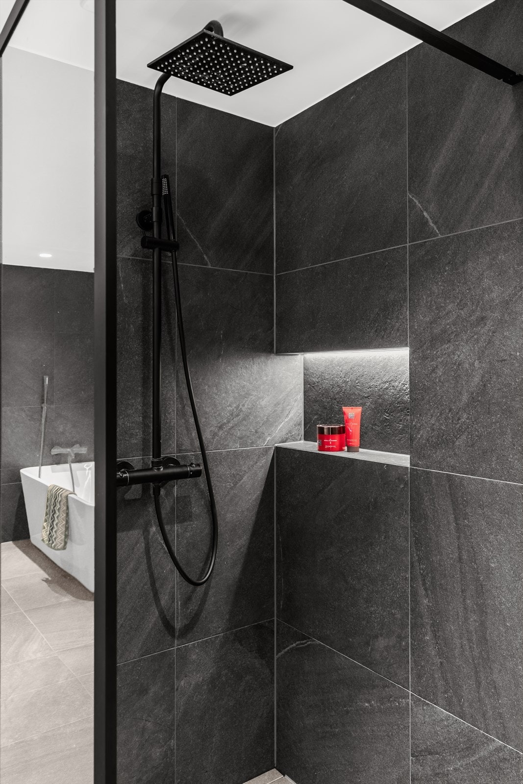 Badet er innredet med både dusjnisje og badekar. Dusjnisje med glassvegg, regnfallsdusj og lekker hylle med lys. Stort badekar med praktisk hylle med lys over. Galleribilde