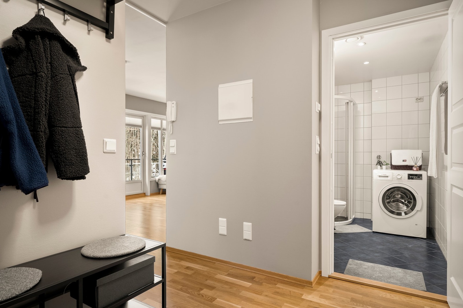 Innbydende åpen entré med lysegrå vegger og gode lagringsmuligheter i skyvedørsgraderobe. Galleribilde