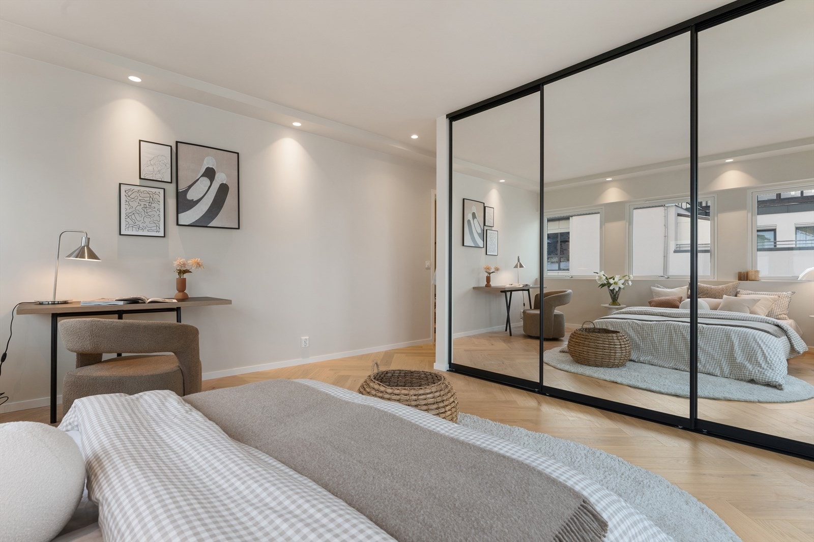 Hovedsoverom med integrert skyvedørsgarderobe i speil, fiskebeinsparkett i eik og behagelig lyssetting. En rolig og elegant atmosfære. Galleribilde