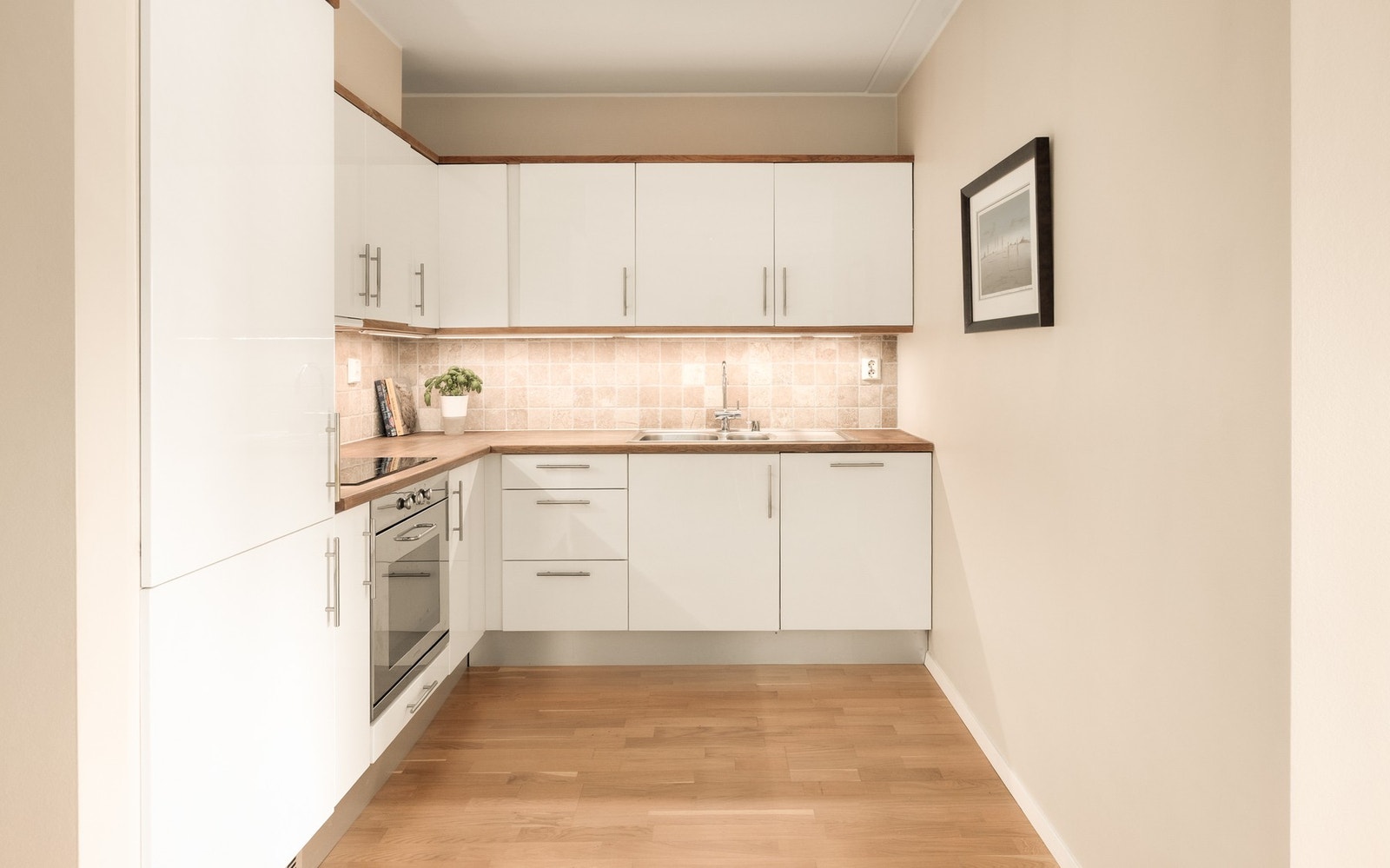 Kjøkkeninnredning med helintegrert løsning med induksjonstopp, stekeovn, oppvaskmaskin og kjøl/frys. Galleribilde