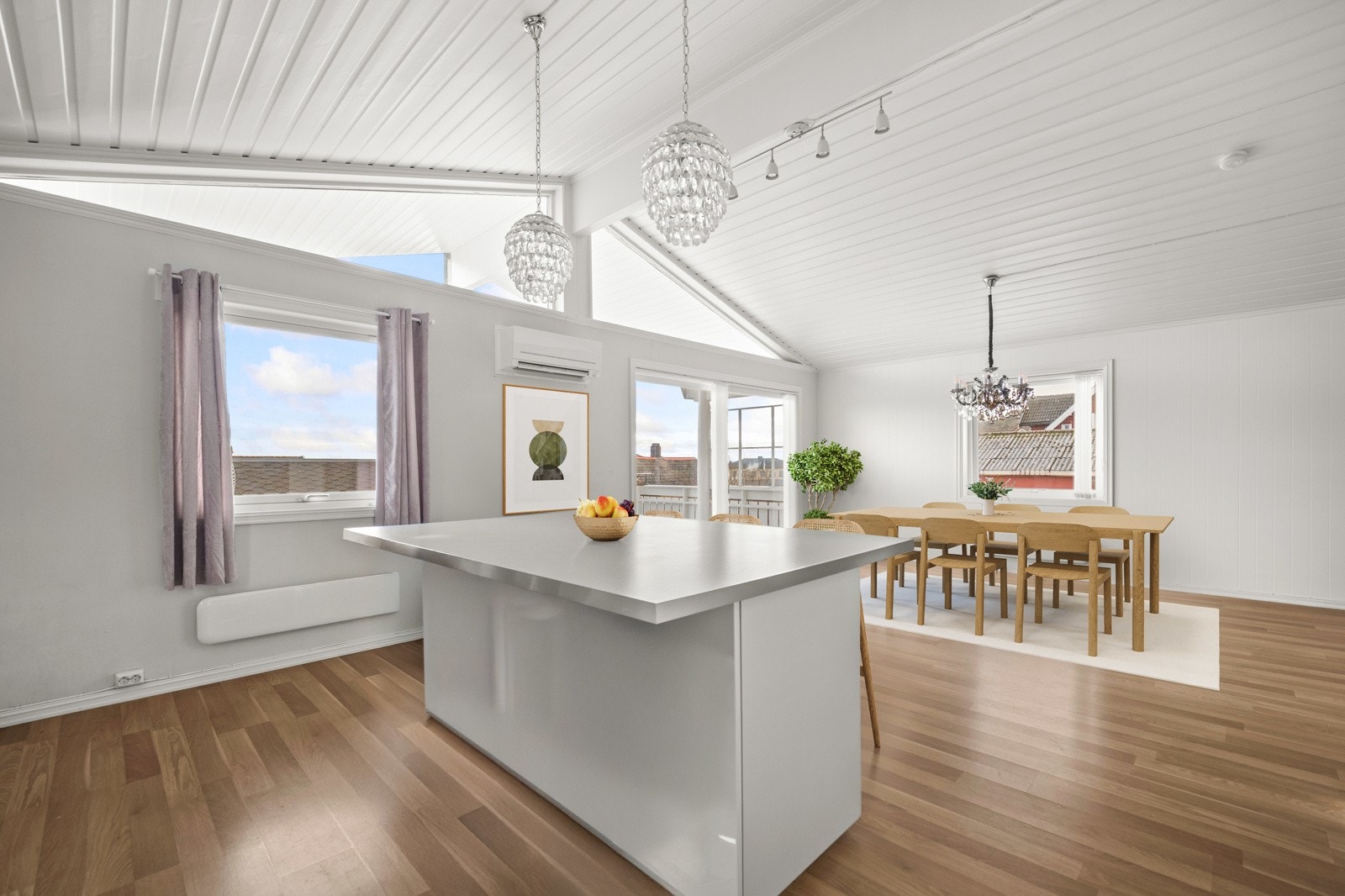 Kjøkkenet ligger med åpen løsning mot spisestuen, med kjøkkenøy som fungerer som et naturlig skille Galleribilde