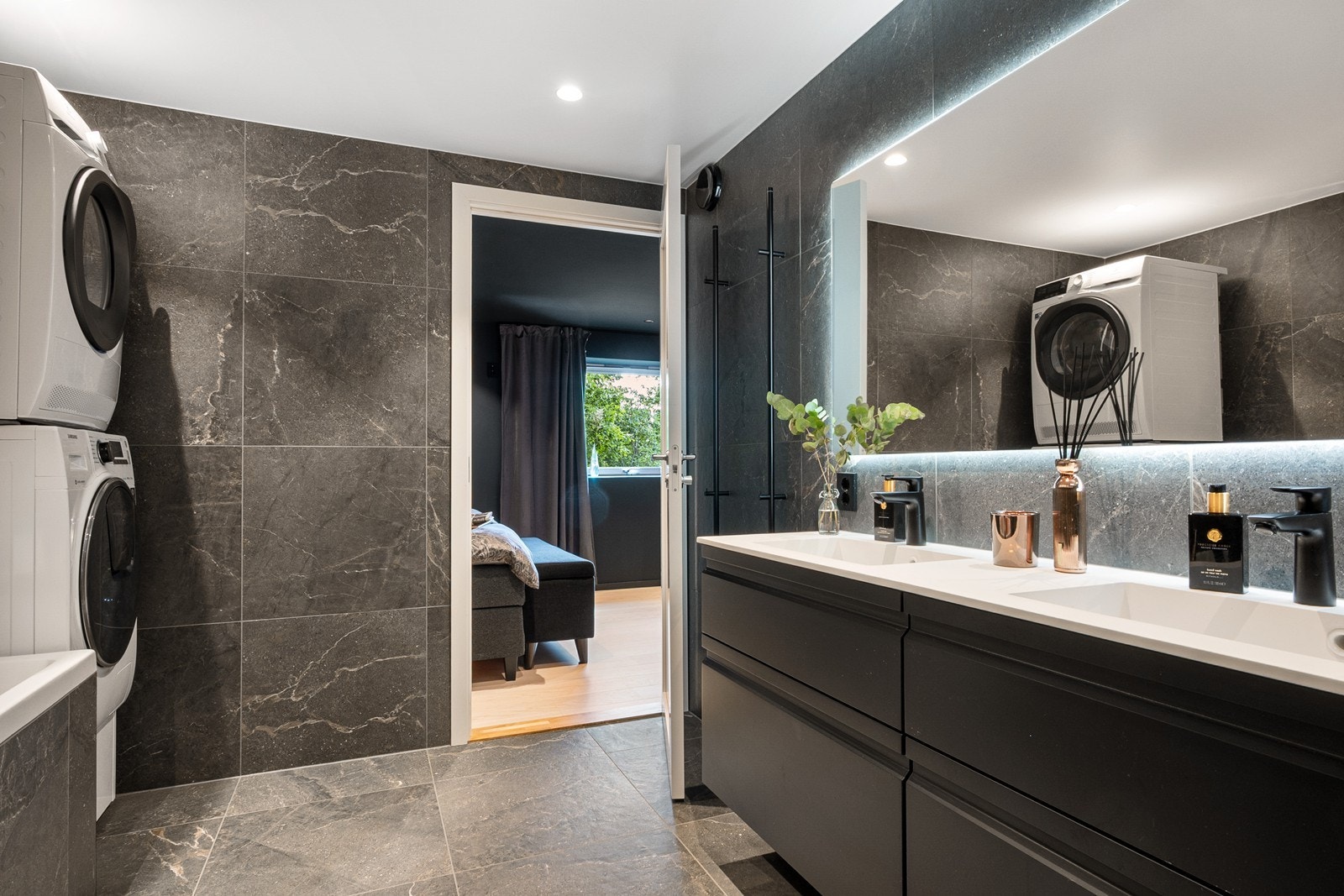 Videre er det elektrisk håndkletørker på vegg, for klesvask er det opplegg for vaskemaskin og tørketrommel. Galleribilde