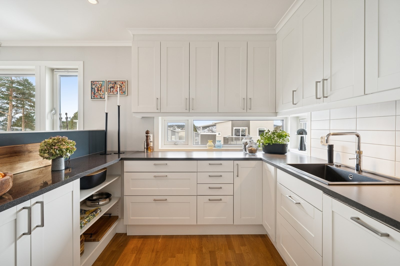 Kjøkkenet har rikelig med naturlig lys og svært god oppbevaringsplass, med overskap som strekker seg helt opp til taket. Den romslige arbeidsbenken girrom for flere kokker i sving samtidig - perfekt for både hverdag og sosiale lag. Galleribilde