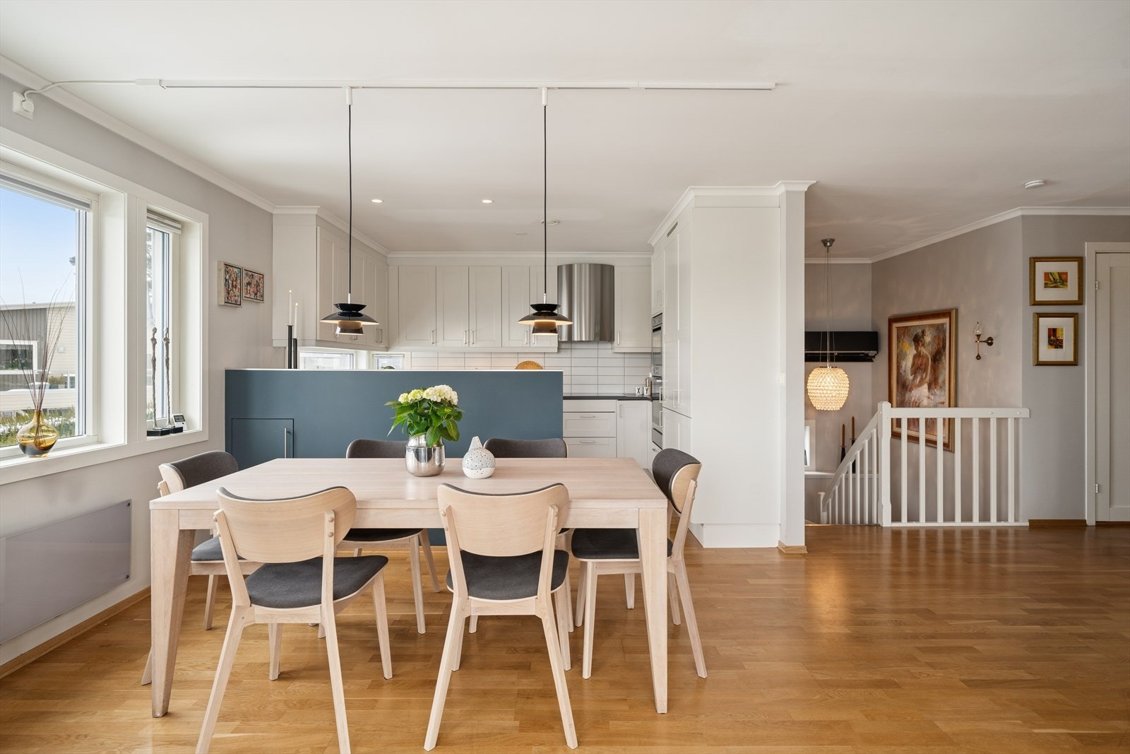 Kjøkkenet er praktisk avdelt fra spisestuen med en stilren halvvegg som både skaper en hyggelig romfølelse og skjuler kjøkkenbenken på en diskret måte. Galleribilde