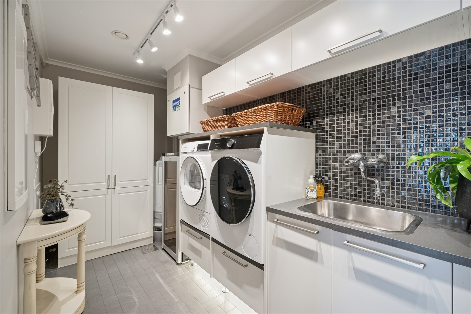 Dette store og praktiske vaskerommet er utstyrt med gjennomtenkt innredning som gir plass til vaskemaskin og tørketrommel samt rikelig med oppbevaring. Galleribilde