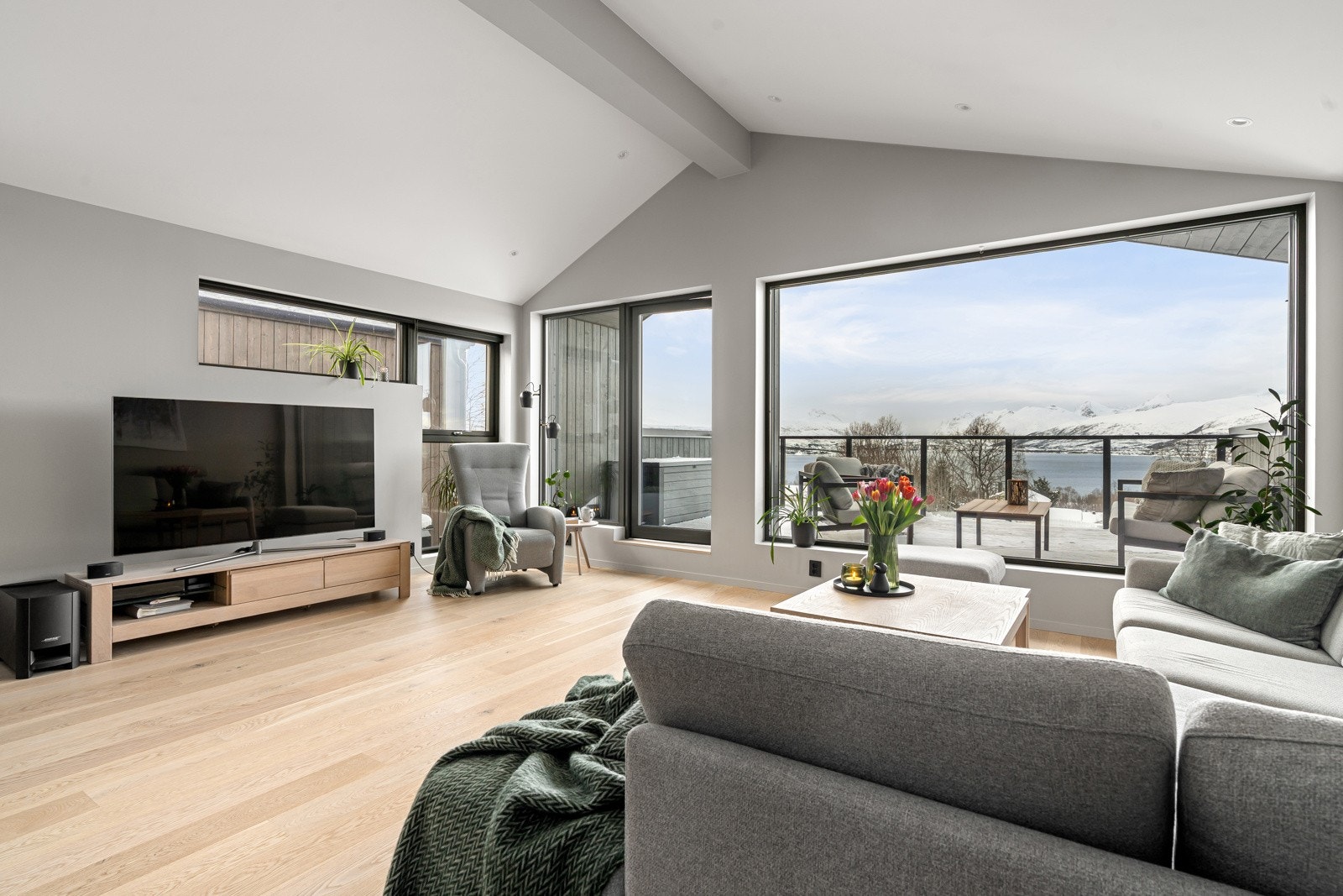 Store vindusflater, rene linjer og peis skaper et eksklusivt og luftig oppholdsrom med perfekt balanse mellom design og komfort. Galleribilde