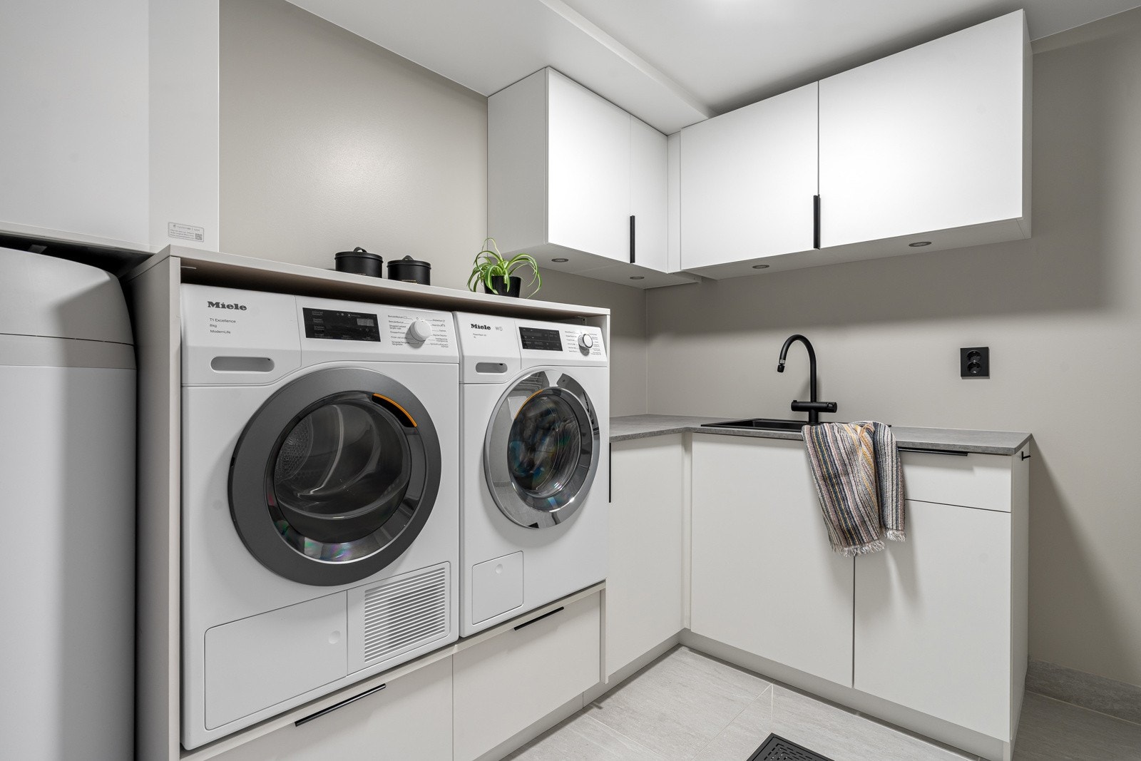 Praktisk og romslig vaskerom med god innredning og tørkemuligheter som ligger i direkte tilknytning til bad og klesrom. Galleribilde
