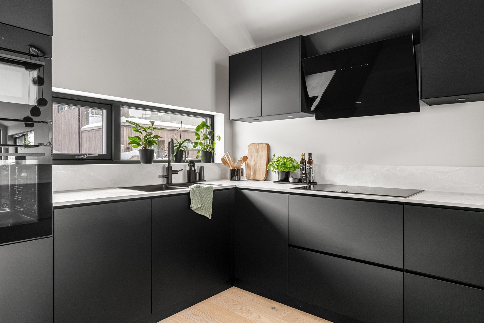 Lekkert kjøkken med integrerte hvitevarer som kjøleskap, fryseskap, oppvaskmaskin, induksjonstopp, kobinert micro og stekeovn. Galleribilde