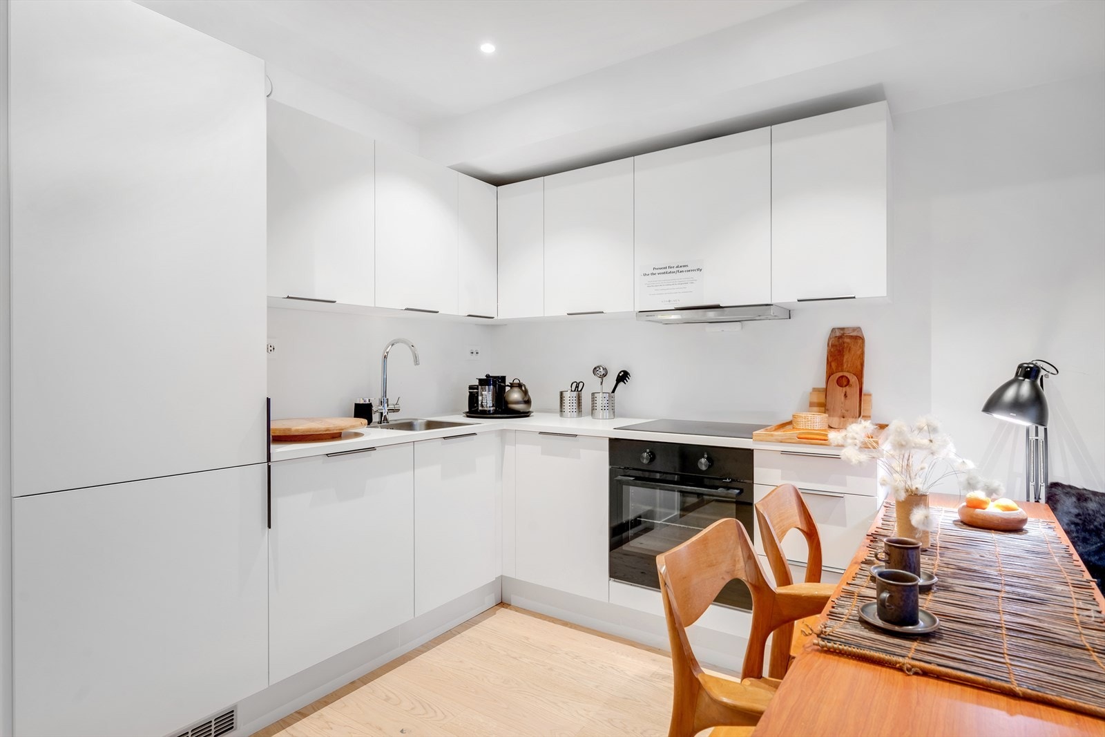 Lyst og tidløst kjøkken med rikelig skap- og benkeplass, samt integrerte hvitevarer. Galleribilde