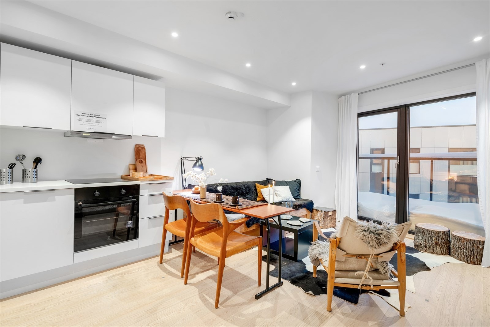 Lys og innbydende stue, med lekkert parkettgulv, glatte overflater og downlights i himling. Galleribilde