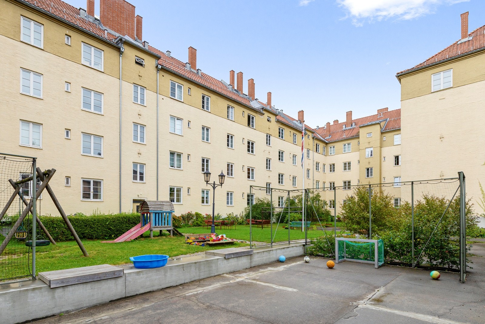 Bakgården er en stor, flott og velholdt fellestomt som fungerer som et naturlig samlingspunkt for beboerne i aksjeselskapet. Galleribilde