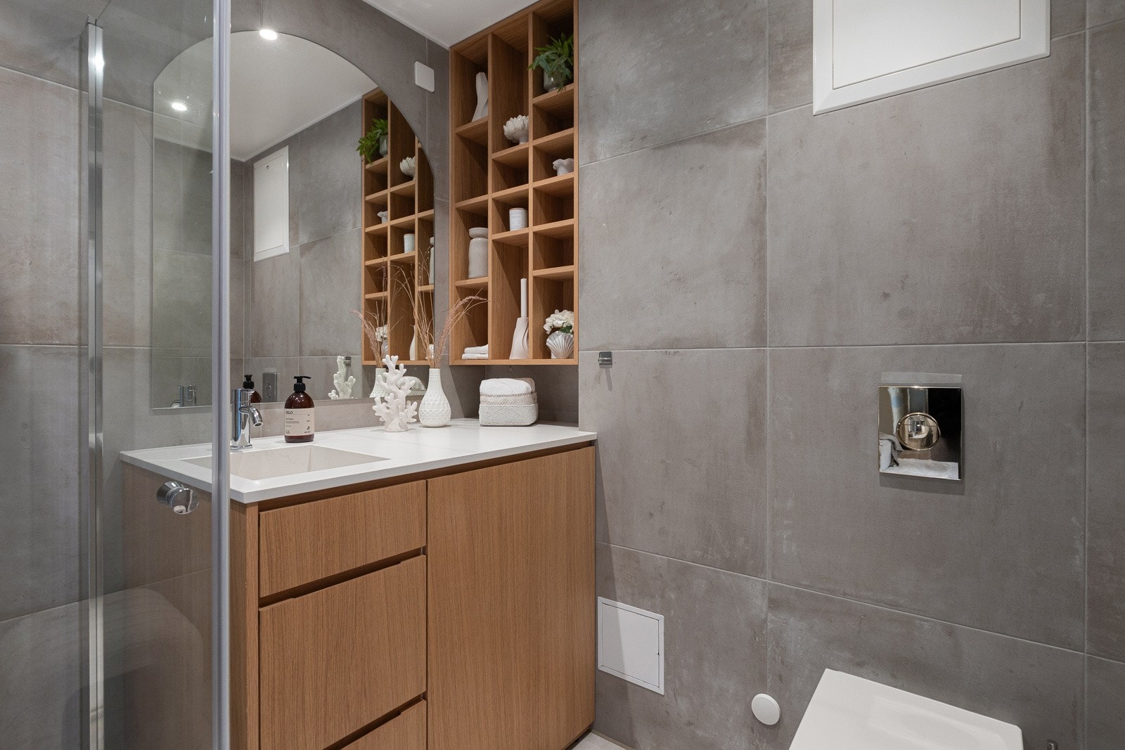 Delikat, flislagt bad fra 2020/2022 med smarte hylleløsninger. Galleribilde