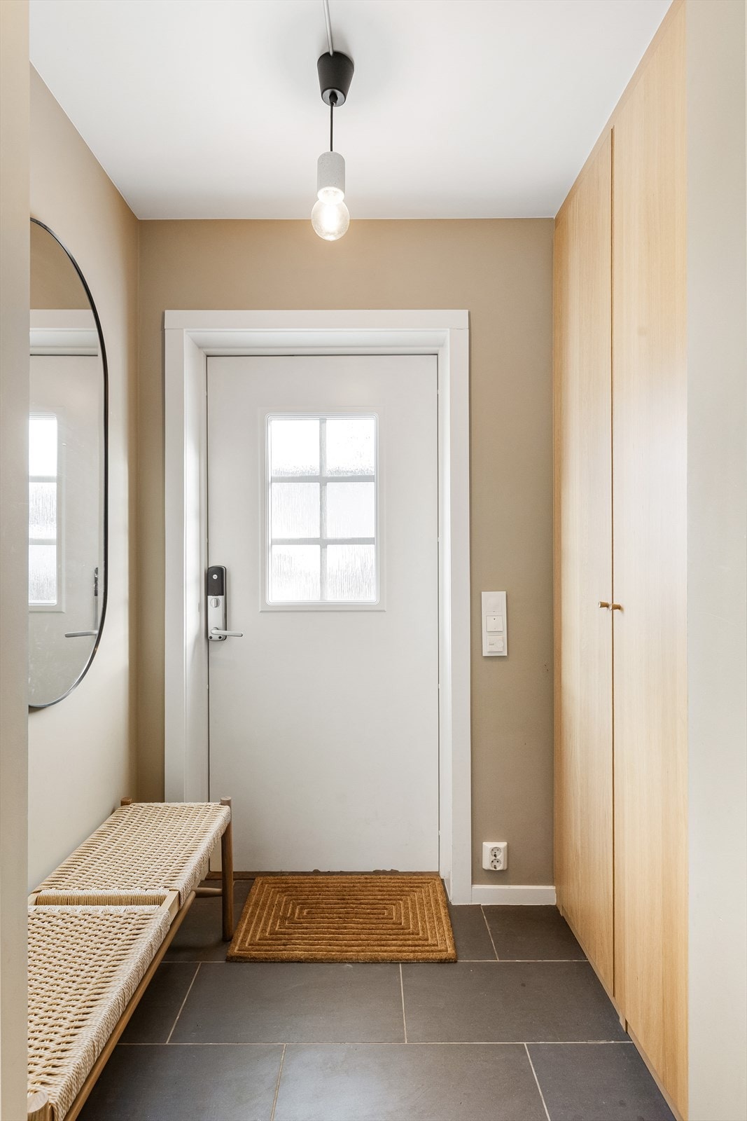 Lys og innbydende entré med flislagt gulv og behagelig gulvvarme. Her er det god oppbevaringsplass i stort garderobeskap med rikelig plass til ytterklær og sko. Galleribilde