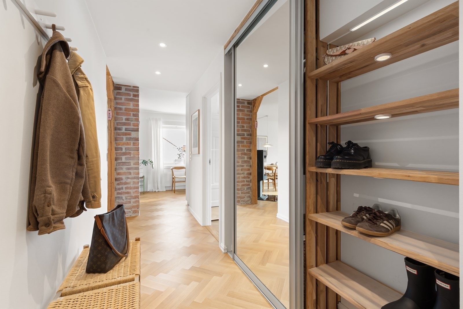 Entreen har plassbygget skyvedørsgarderobe med speilfronter og innredning i heltre eik med integrert belysning. Galleribilde