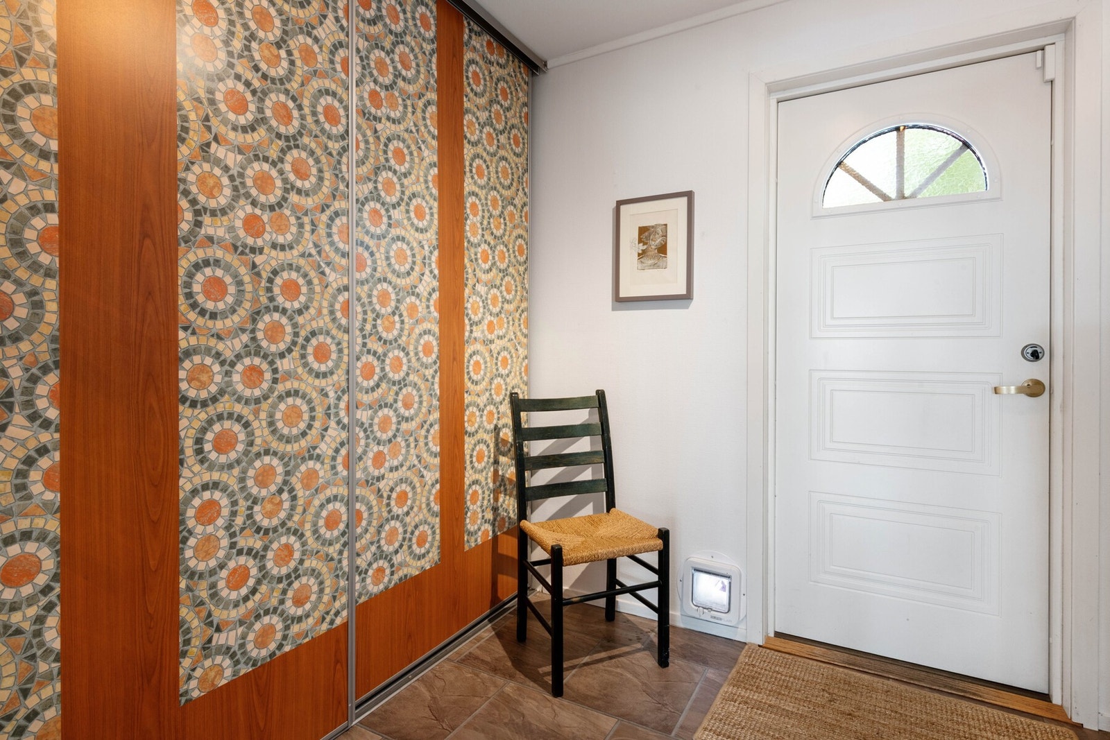 Velkommen inn. Lys og romslig entré med malt tapet på vegger og flislaminat med steinmotiv på gulv. Stor skyvedørsgarderobe. Galleribilde