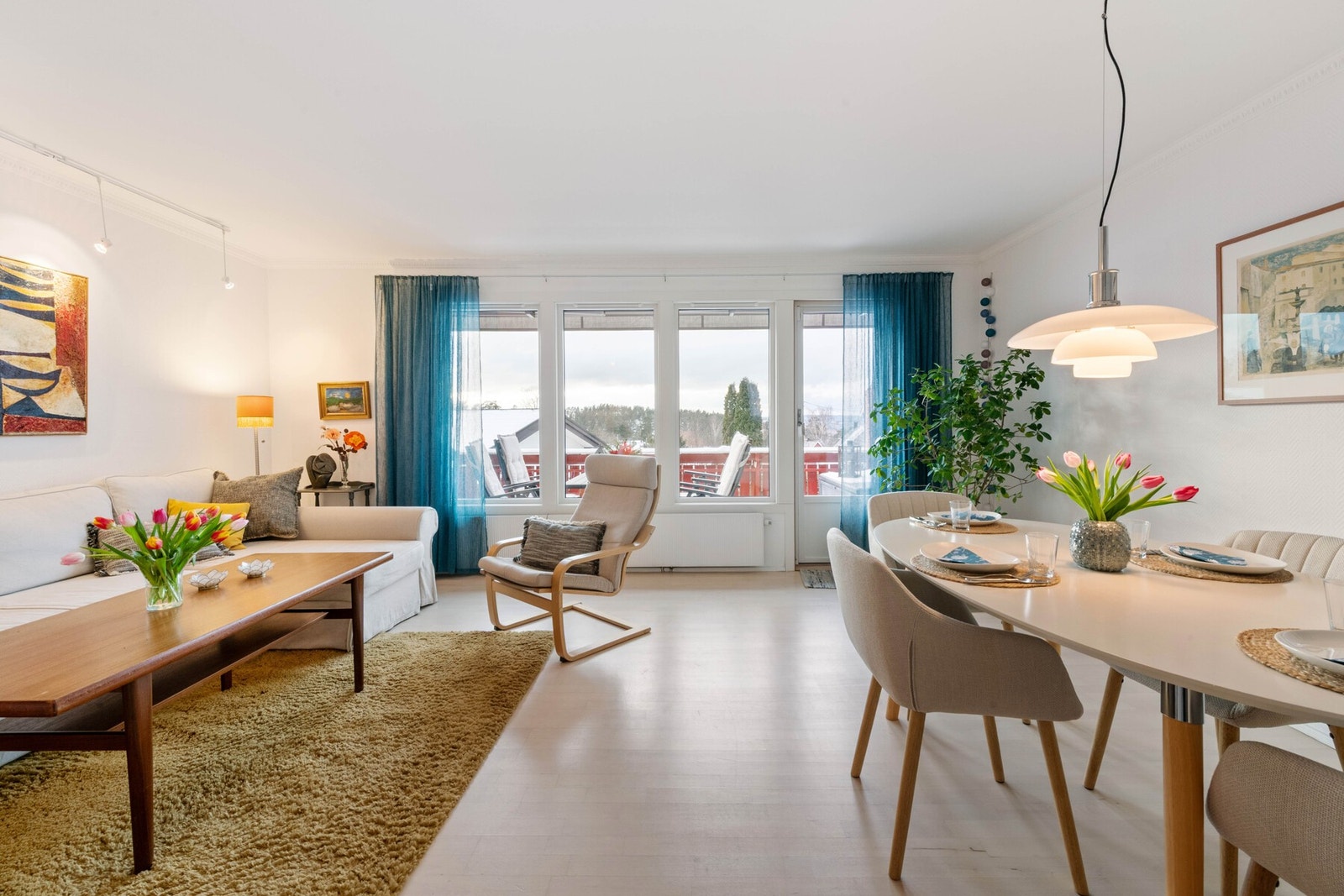 Lys og romslig stue på 22 m² med parkettgulv og hvitmalt tapet på vegger. Galleribilde