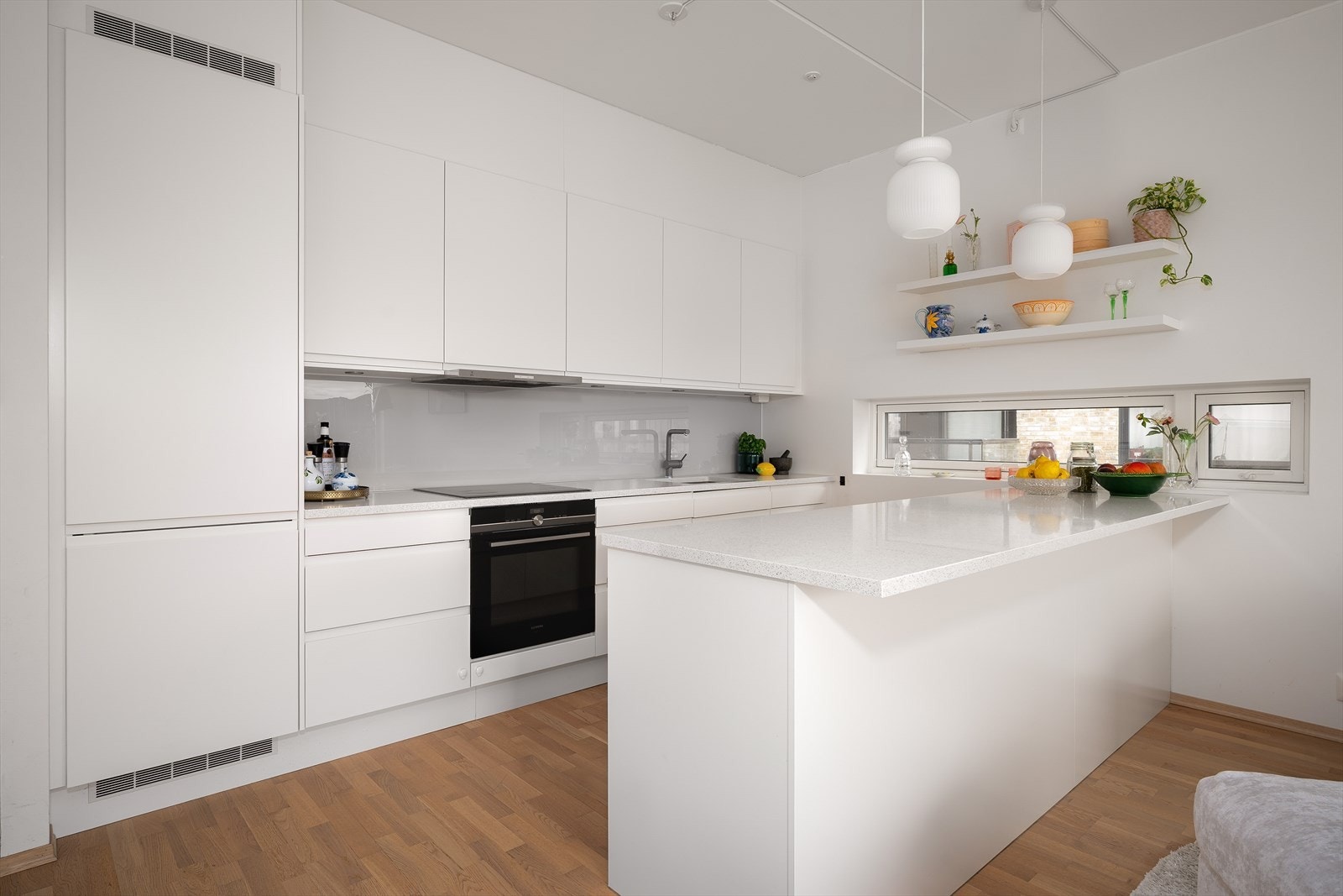 Kjøkken med integrerte hvitevarer og stor kjøkkenøy - både praktisk og sosialt. Galleribilde